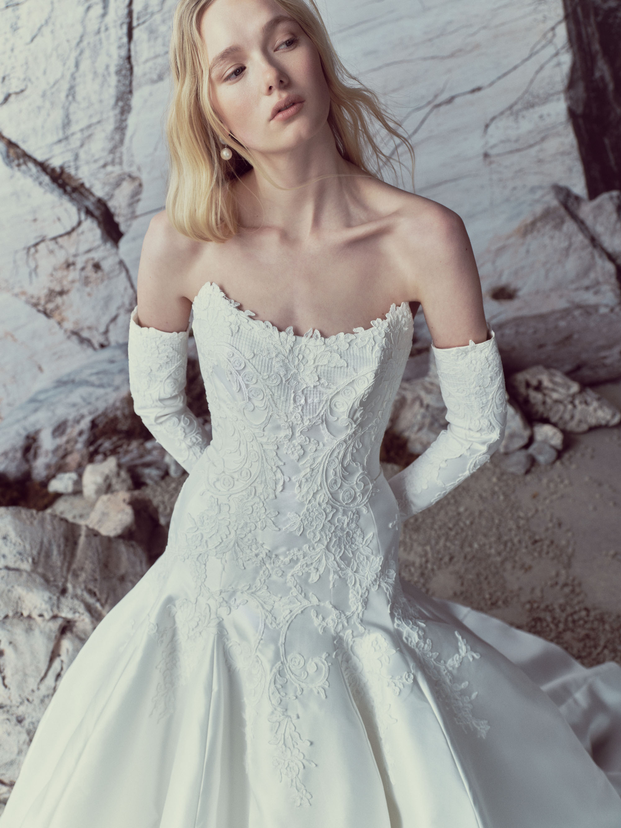 Close-up of Luma showing the sculpted cat-eye bodice, hand-placed Alençon lace, and detachable silk magnolia sleeves.