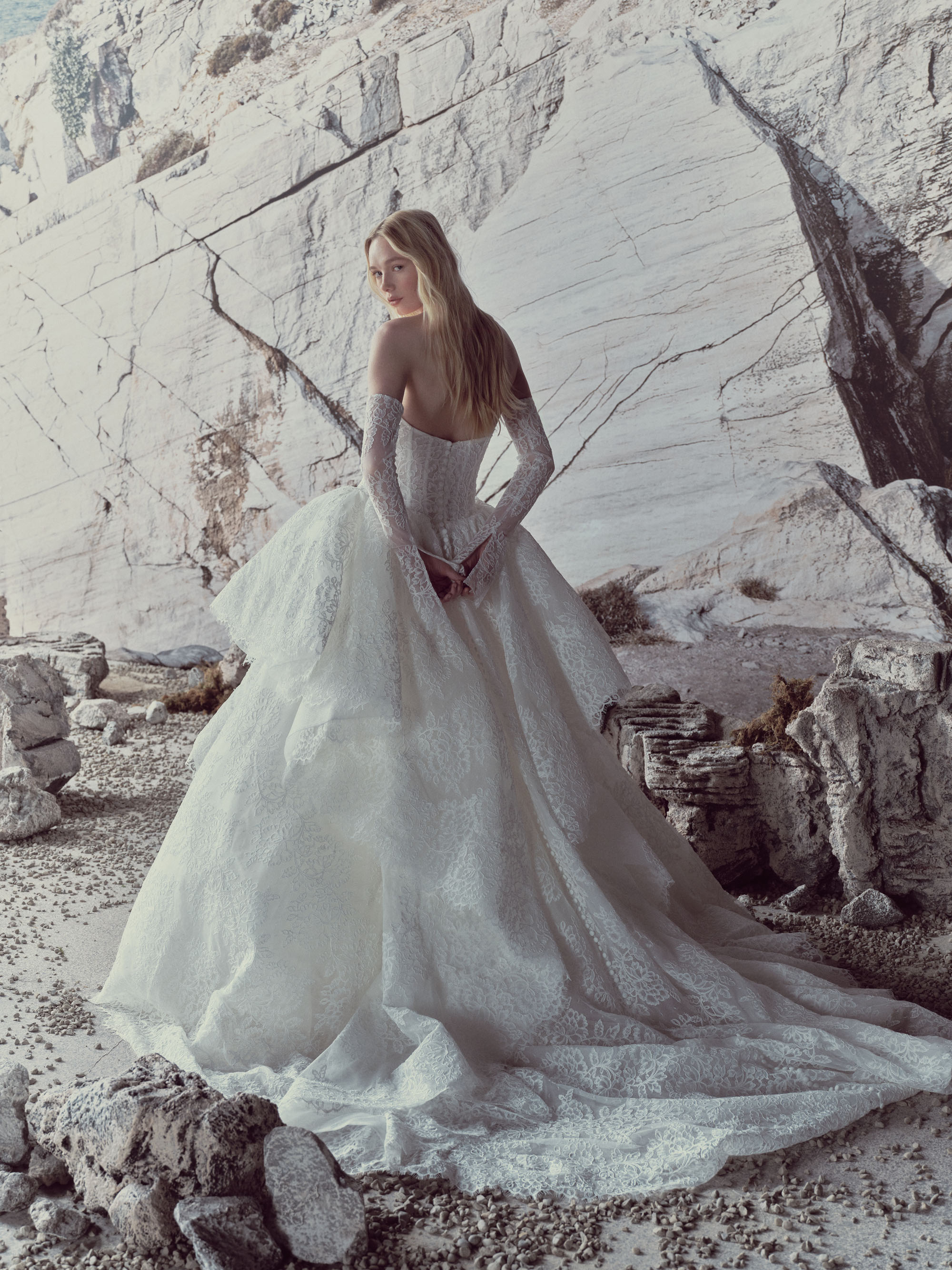 Full view of Vivienne showing the structured corset bodice, detachable lace sleeves, and voluminous tiered skirt.