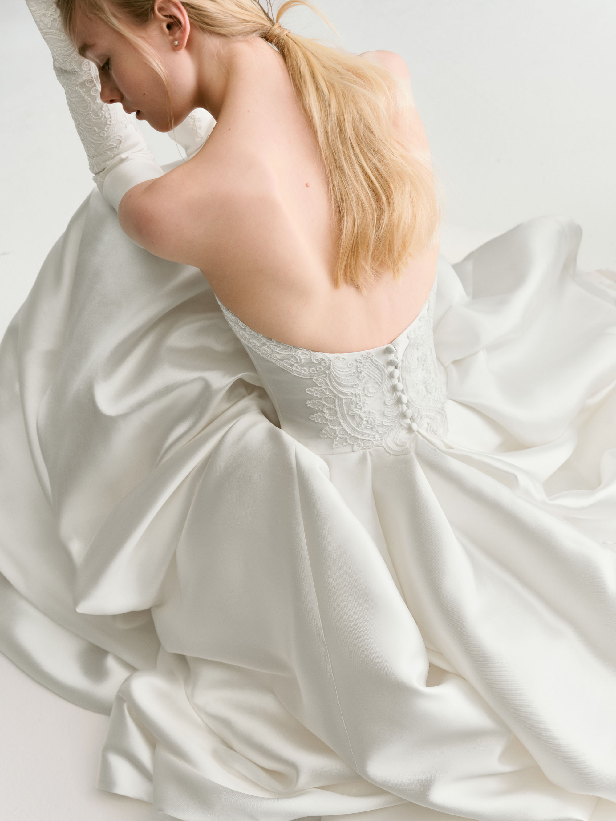 Close-up of Drift showing the sweetheart bodice, hand-applied lace, and softly gathered mikado folds.