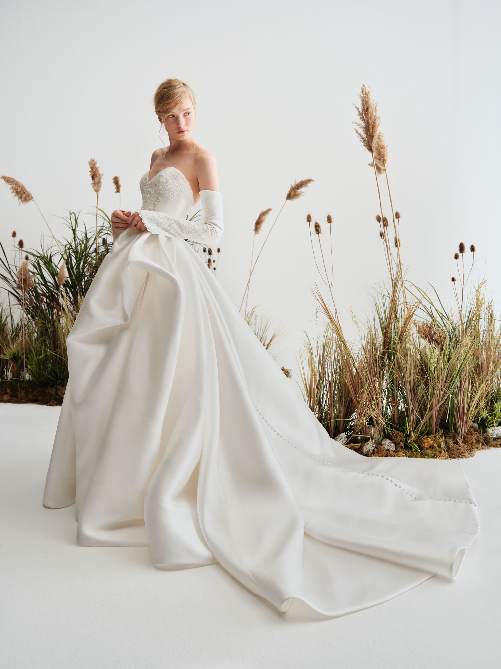 Drift Alyne SS27 sweetheart mikado ball gown with hand-applied lace, detachable sleeves, and a richly pleated skirt, shown from the front.
