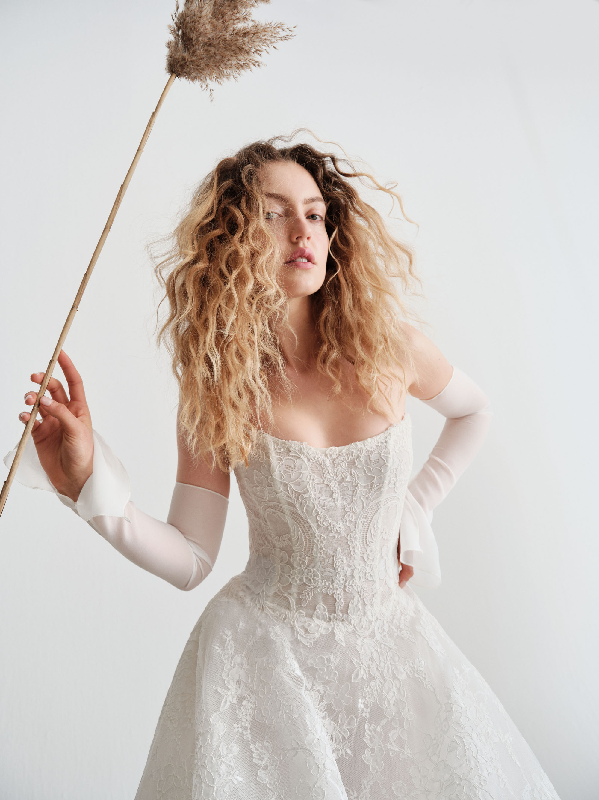 Close-up of Reign showing the sculpted cat-eye neckline, fitted lace bodice, and detachable lace sleeves.