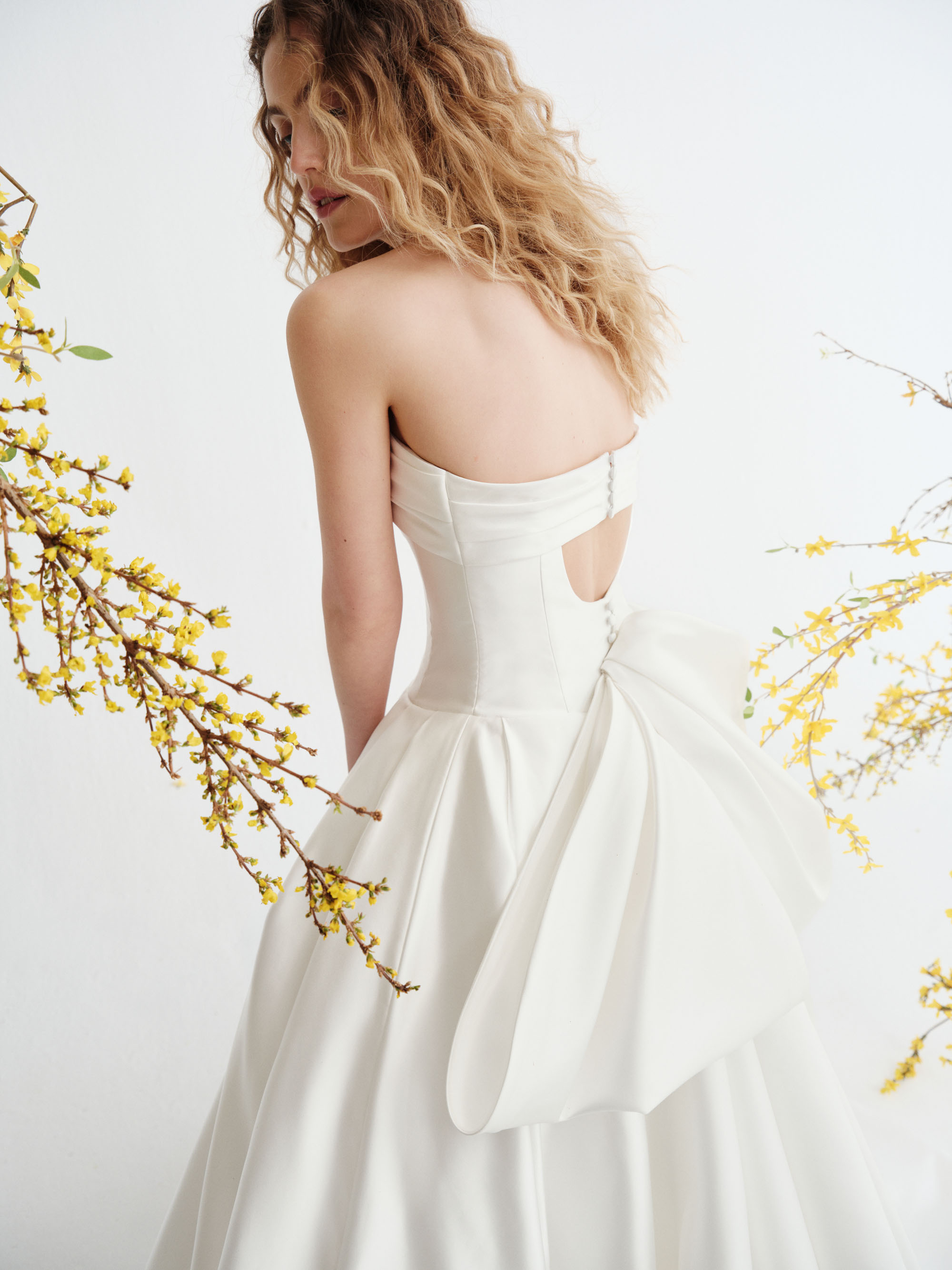 Close-up of Reeve showing the sculpted strapless bodice, organically draped cuff neckline, and smooth satin waist.