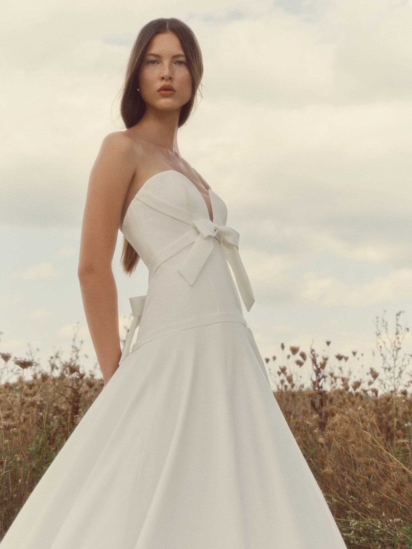 Pearl strapless ballgown with a sculpted sweetheart neckline, elongated bodice, softly draped bias bands, and a full airy skirt.