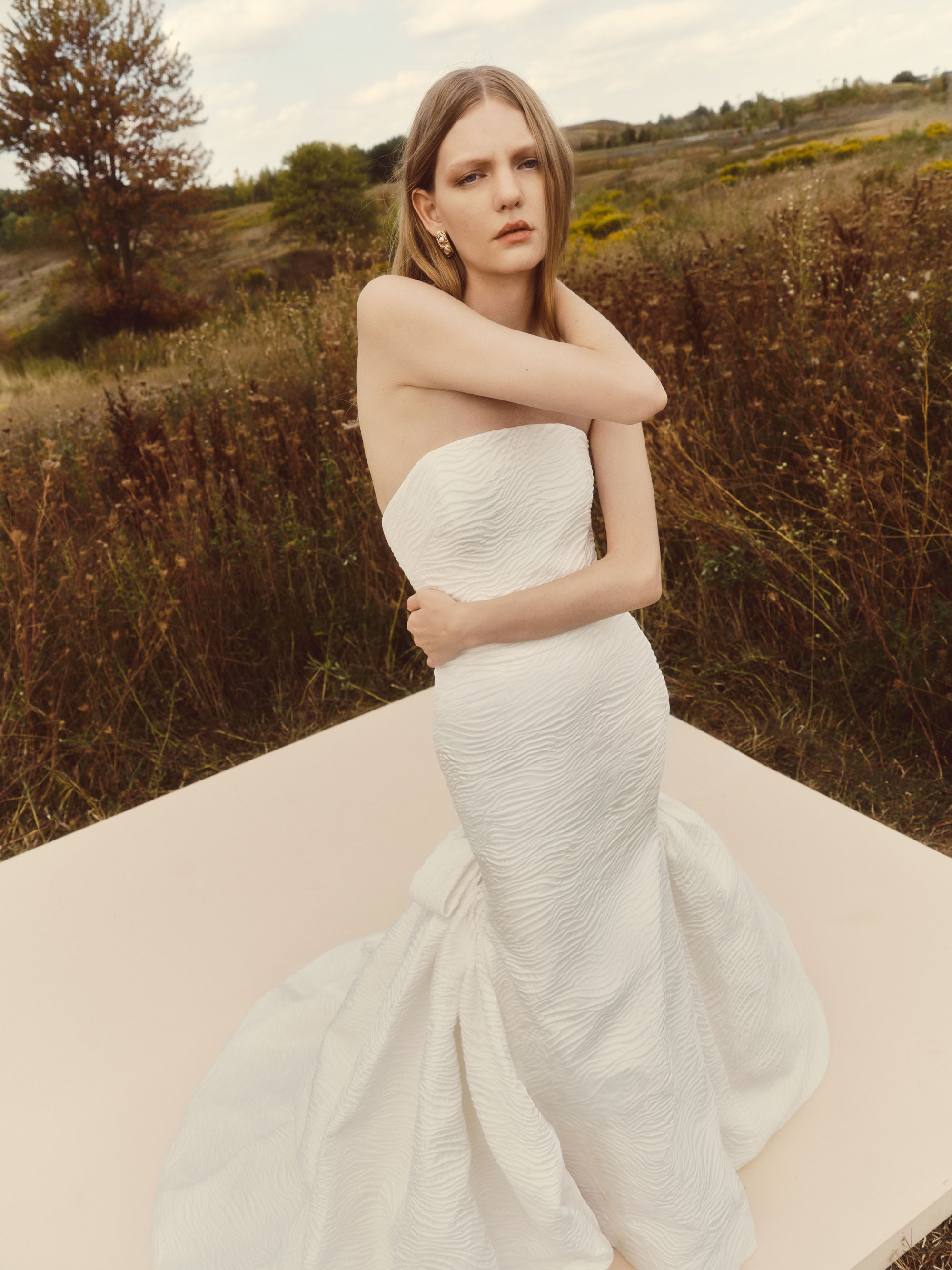 Close-up of Dew showing the softly draped strapless bodice and floral brocade texture.