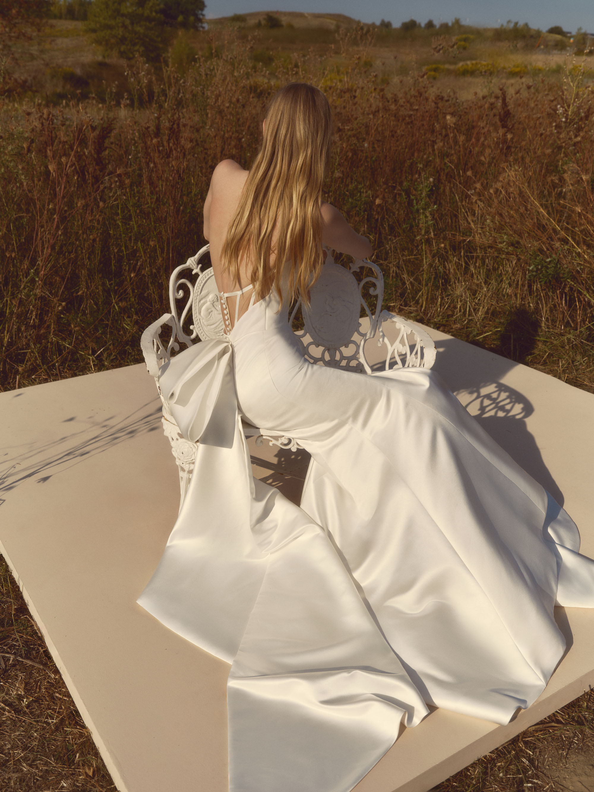 Back view of Echo showing the sheer boned back, oversized bow, and sculptural trailing tails.