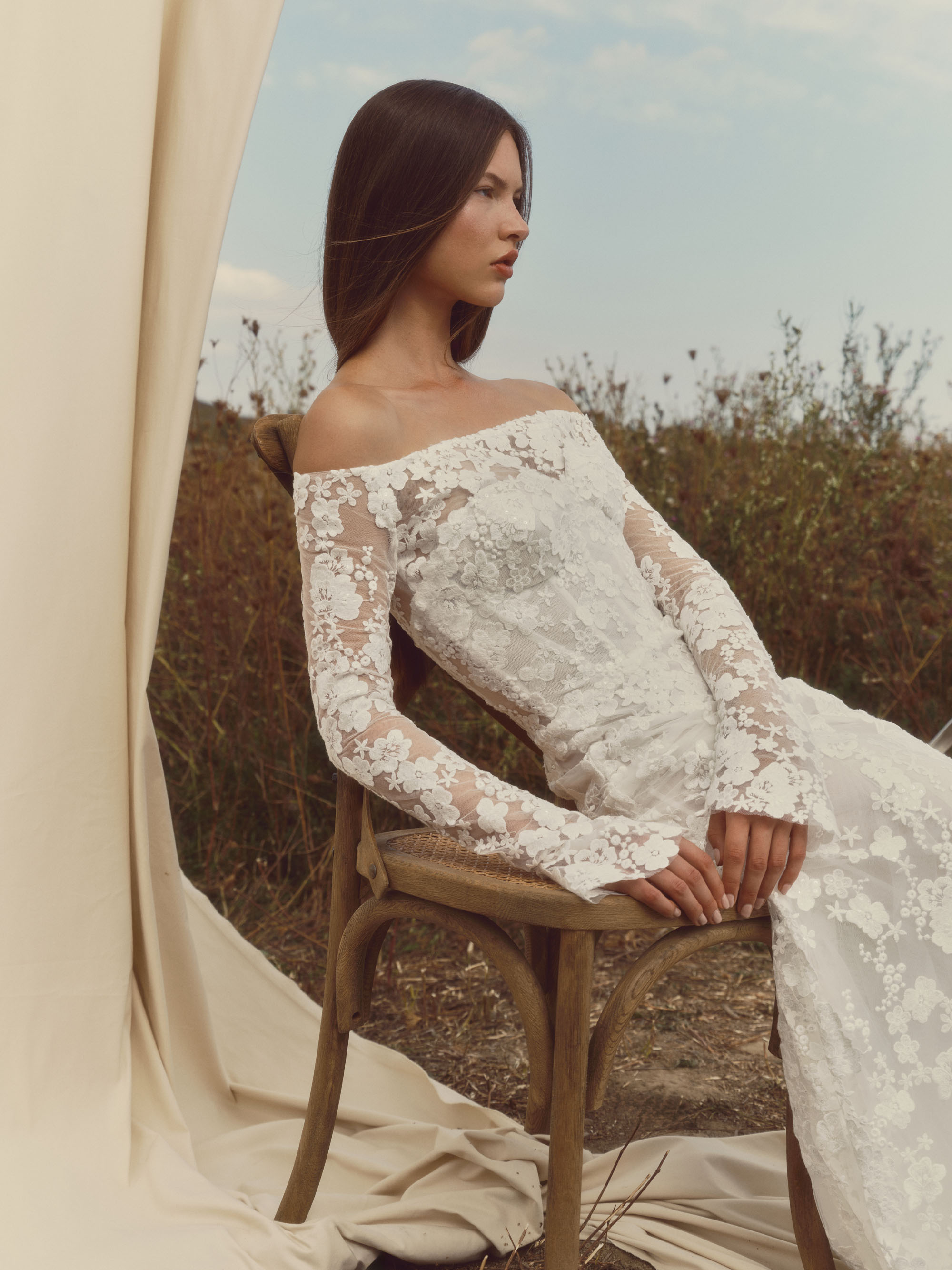 Side view of Halo showing the fitted floral lace silhouette, detachable bolero, and elongated train.