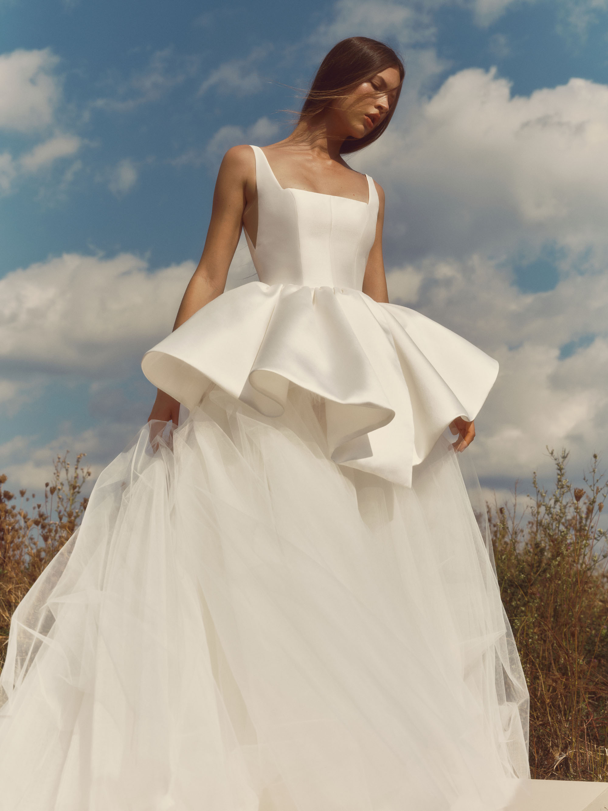Ripple Alyne FW26 sculpted ball gown with square neckline, delicate straps, layered peplum, and airy tulle skirt, shown from the front.