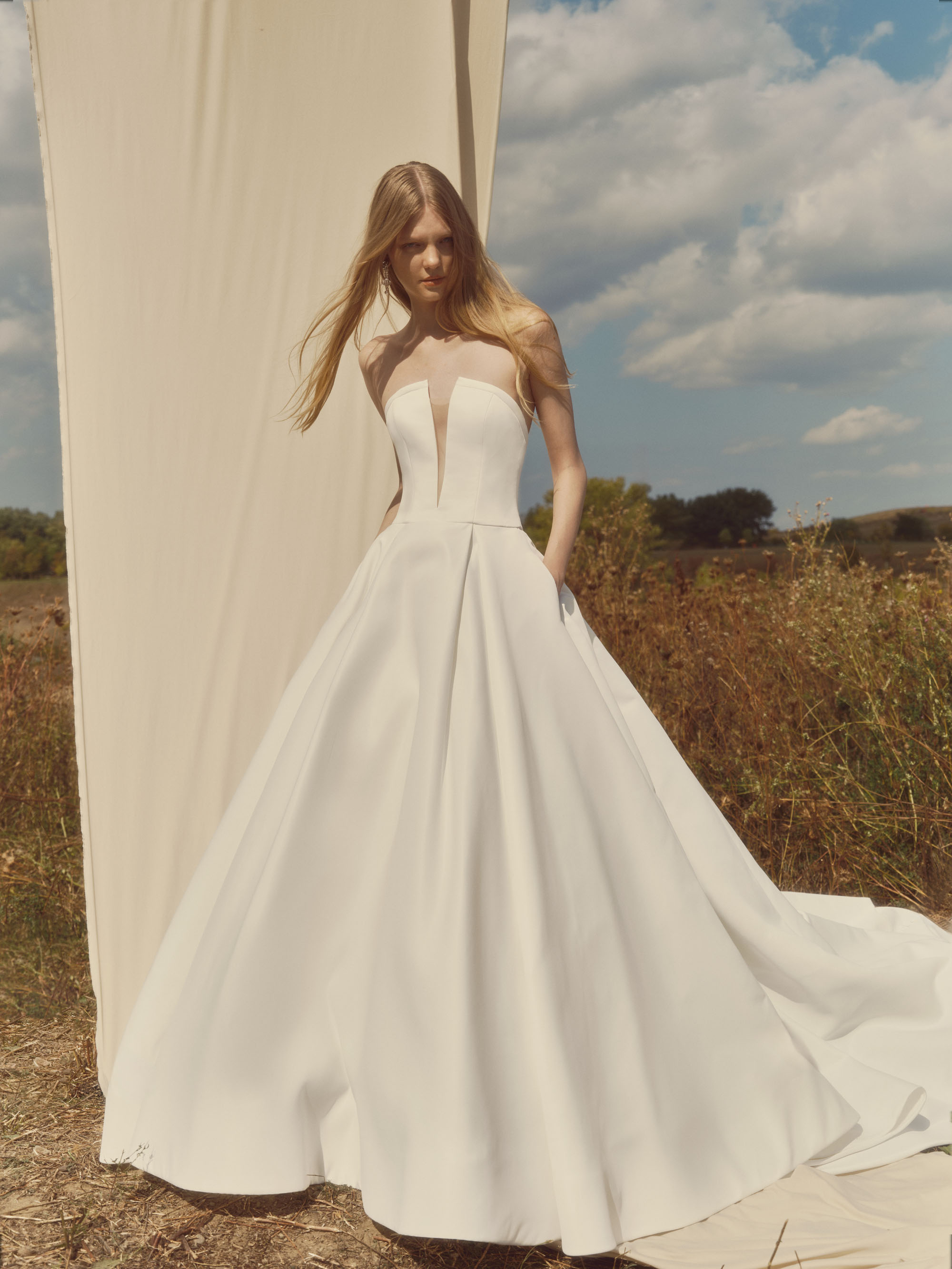 Serene matte satin ball gown with plunging neckline, sculpted bodice, and voluminous skirt, shown from the front.