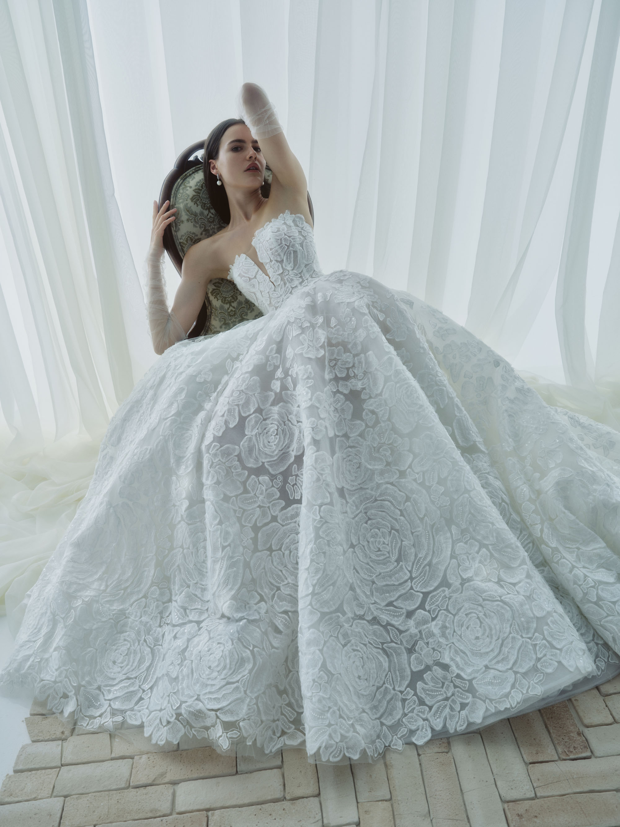 Mist RIVINI FW26 strapless ball gown with cat-eye neckline and voluminous floral lace skirt, shown from the front.