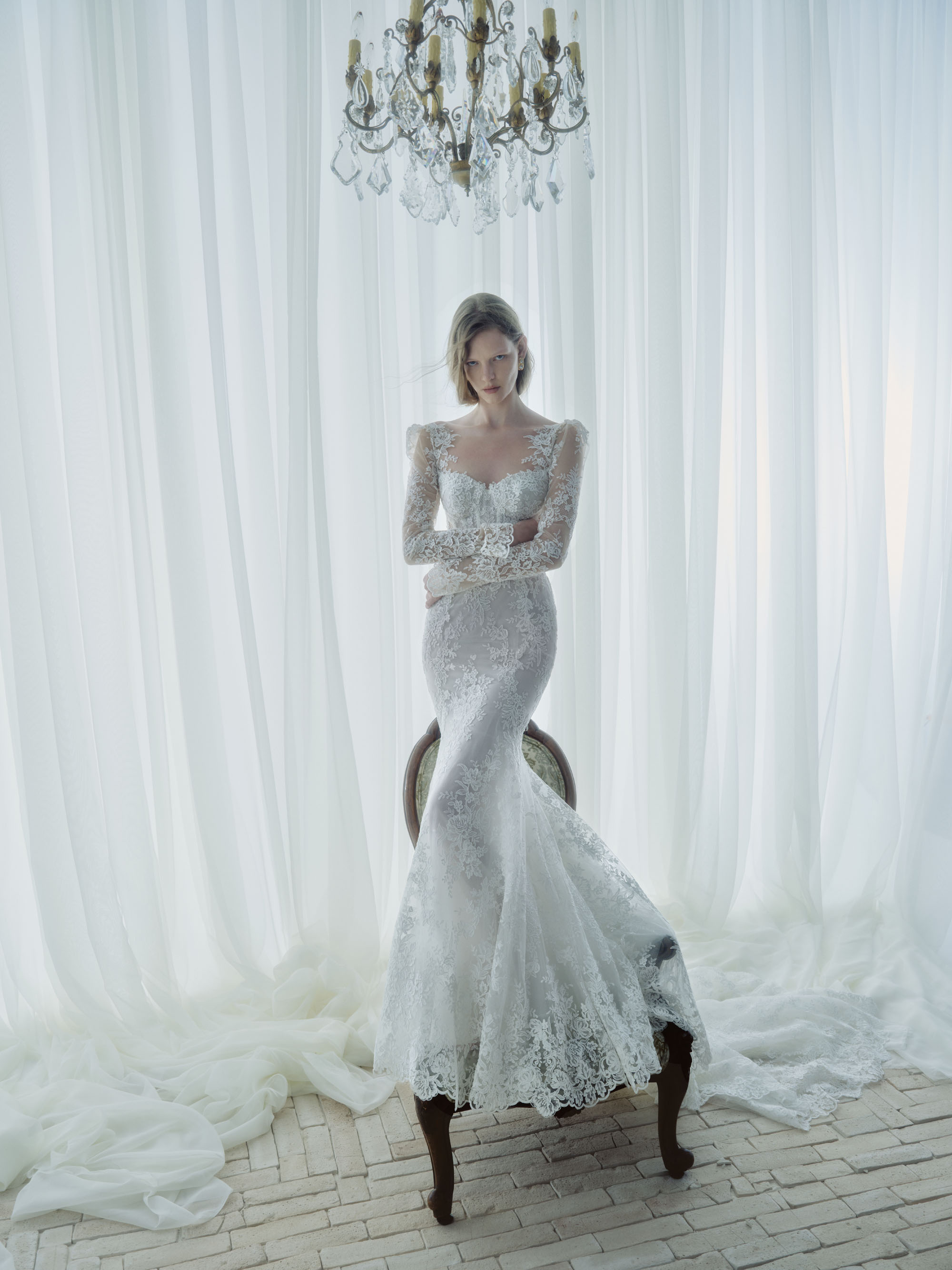 Serenade RIVINI FW26 Alençon corded lace fit-and-flare gown with sculpted sleeves and corseted bodice, shown from the front.