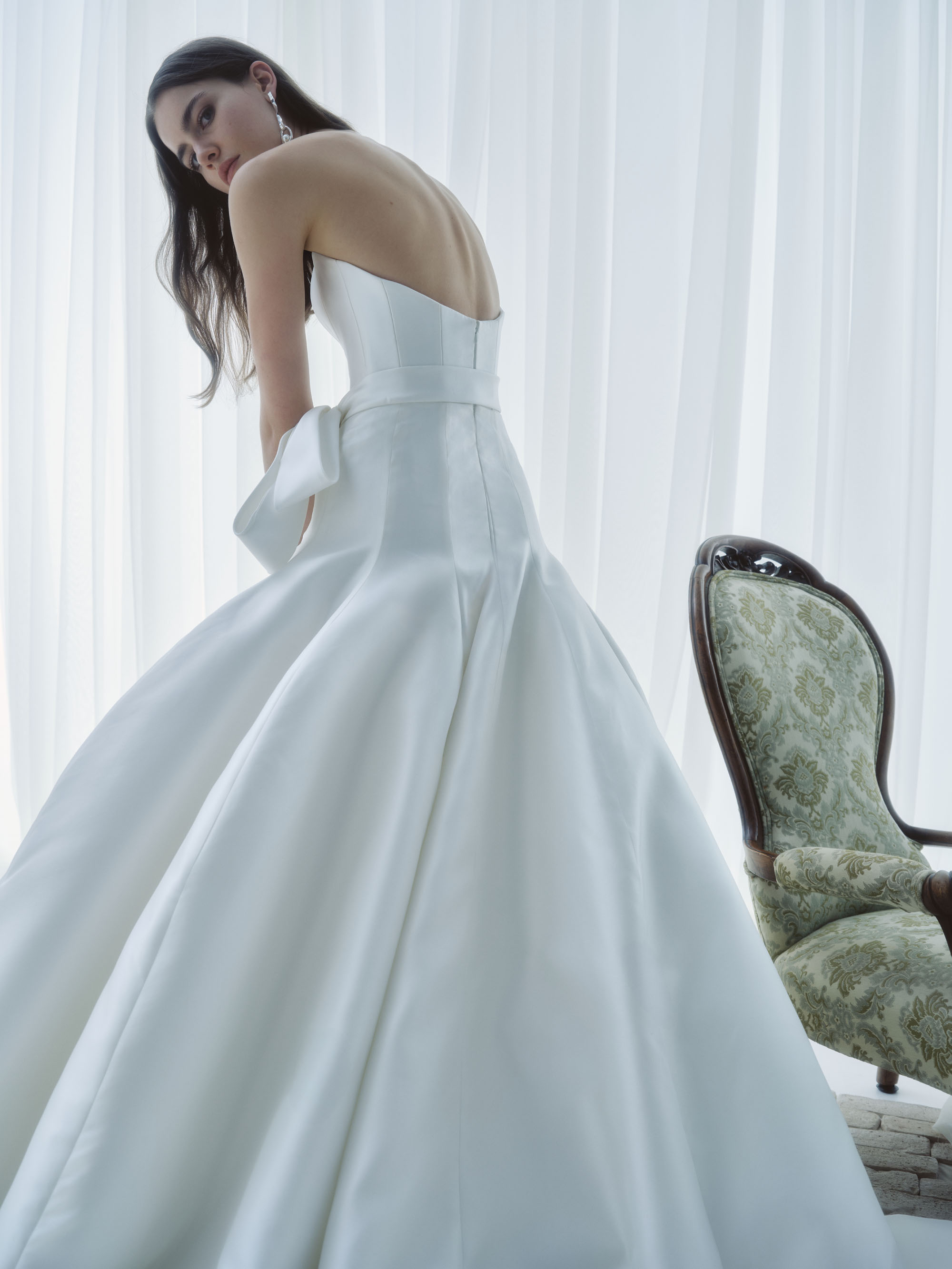Side view of Sublime showing the structured strapless bodice, cinched sash, and voluminous silk skirt.