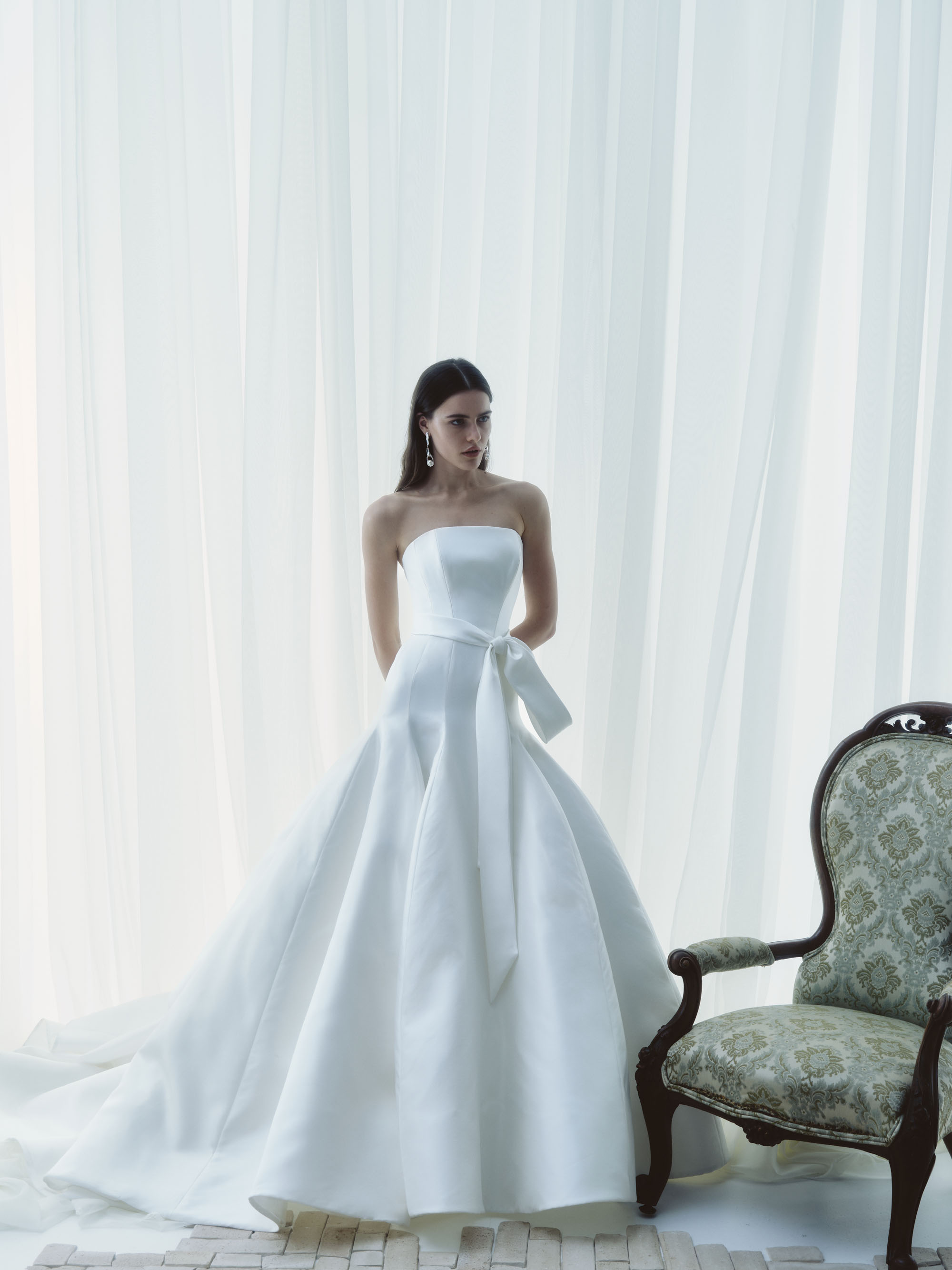 Sublime RIVINI FW26 strapless silk gown with a clean bodice, sculpted skirt, and softly tied sash, shown from the front.