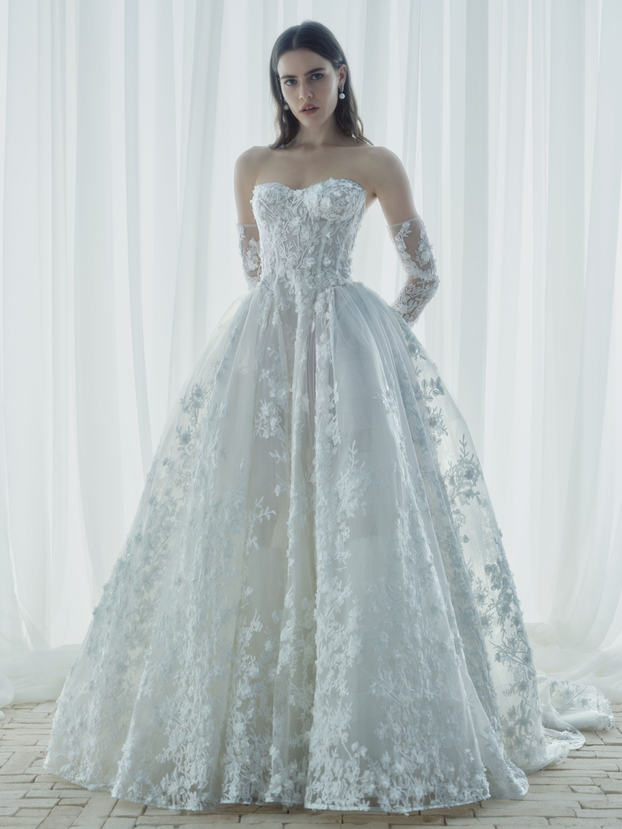 Whisper RIVINI FW26 organza floral lace ball gown with structured corset bodice, detachable glovelettes, and voluminous skirt, shown from the front.