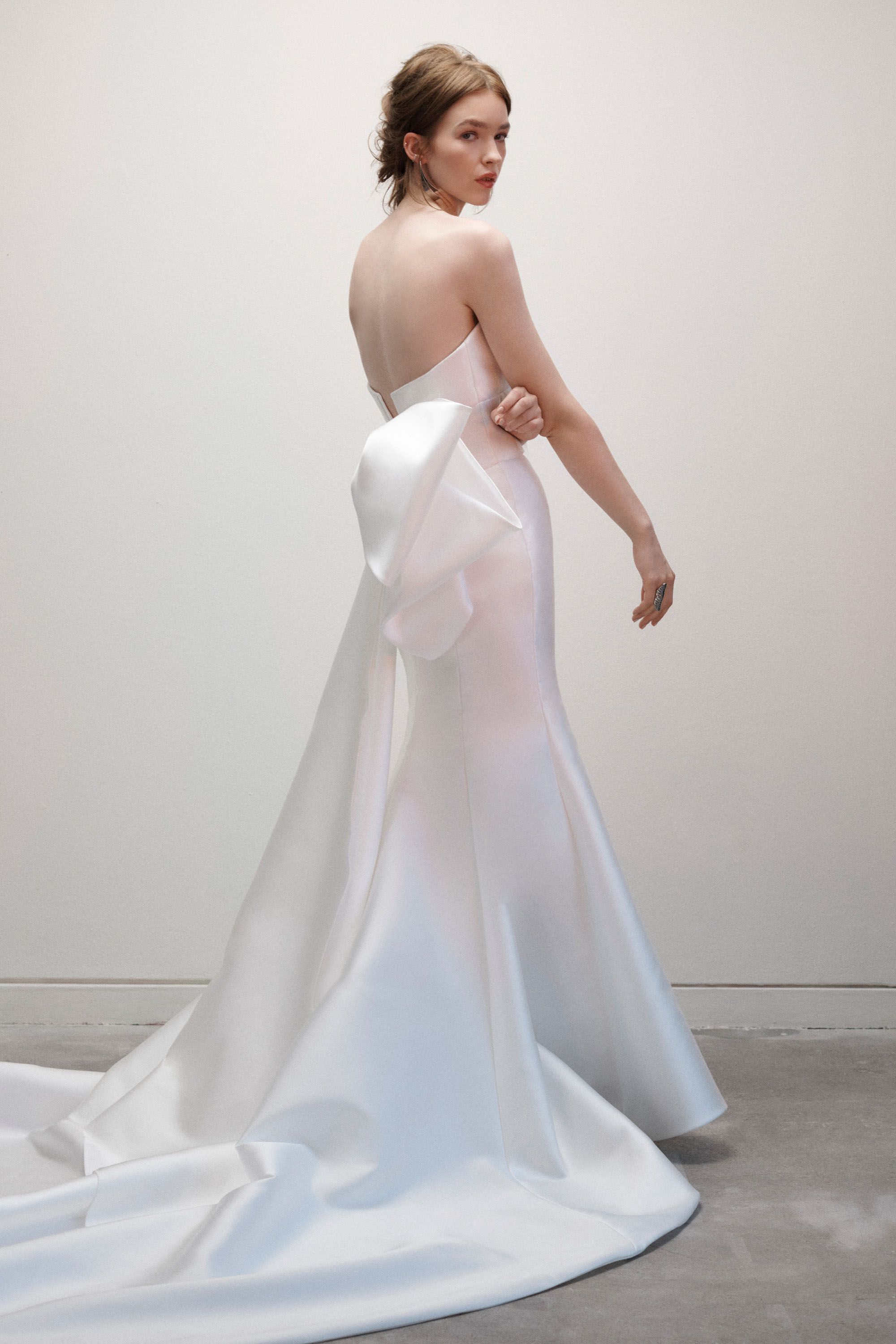 Back view of the Lauren gown, showing the draped bodice, fitted skirt, and couture back bow.
