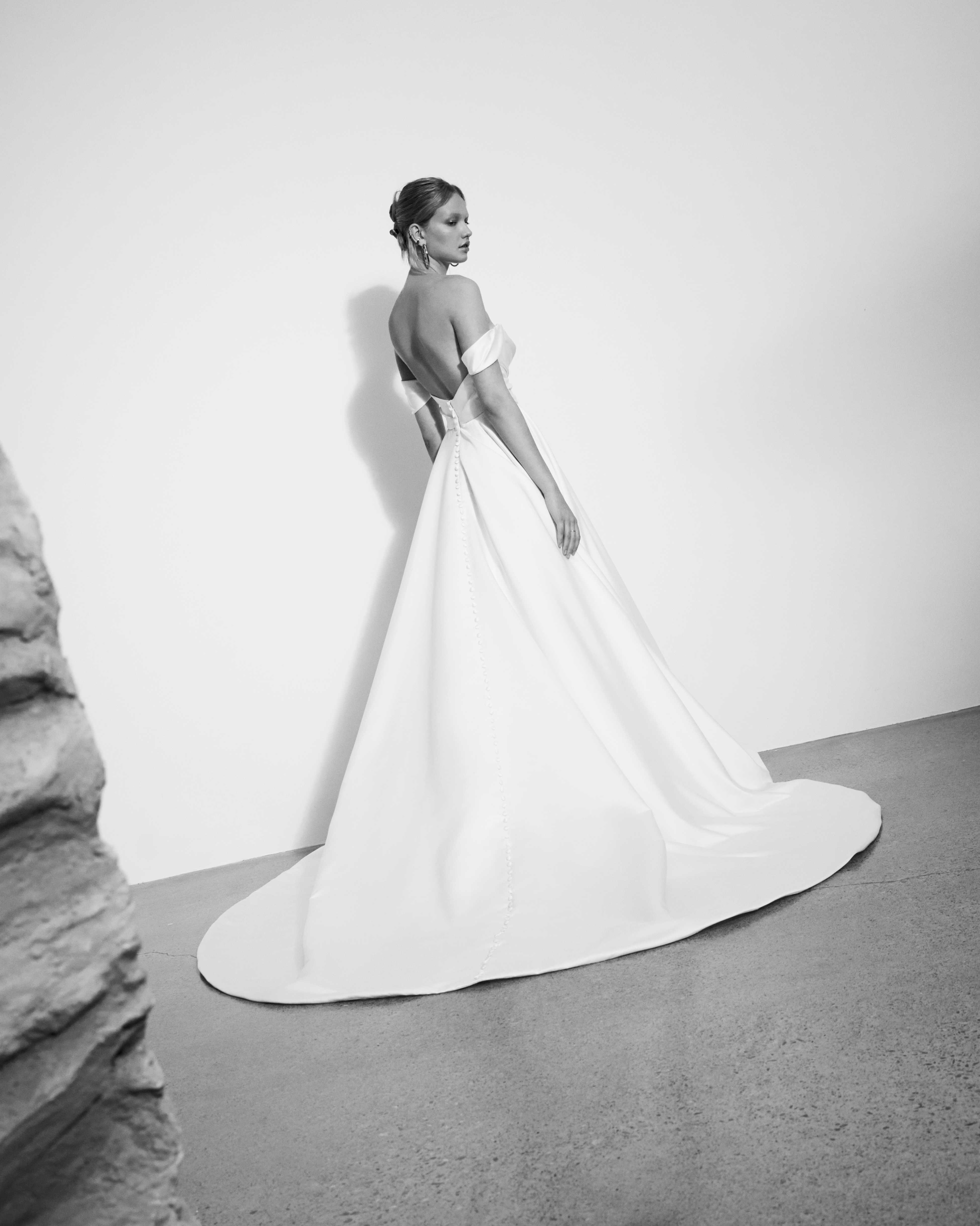 Back view of Mackenzie satin ball gown with off-the-shoulder draping and buttons down the back.