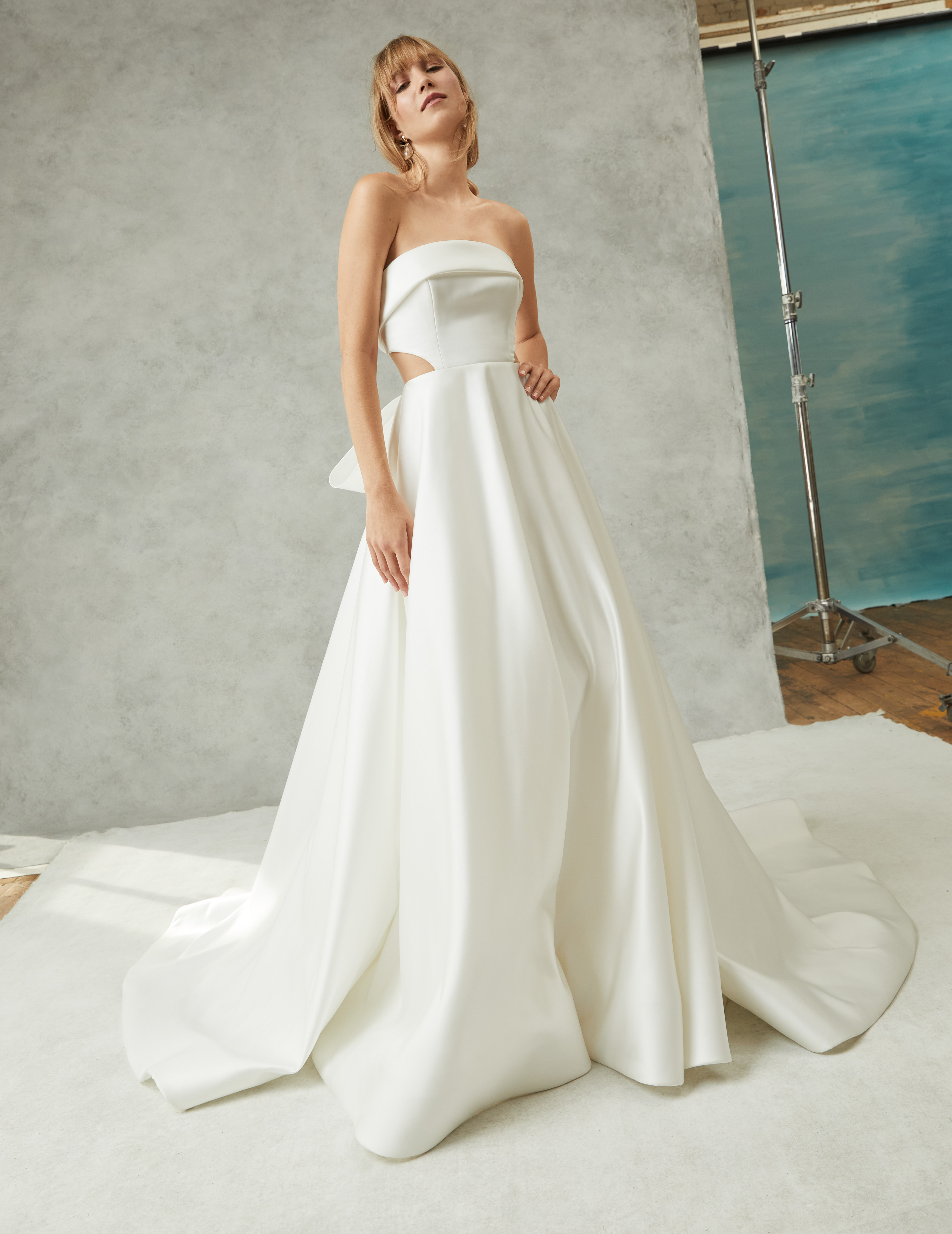 Regina strapless satin ball gown with draped banded neckline, illusion tulle cut-outs, and grand bow, shown from the front.