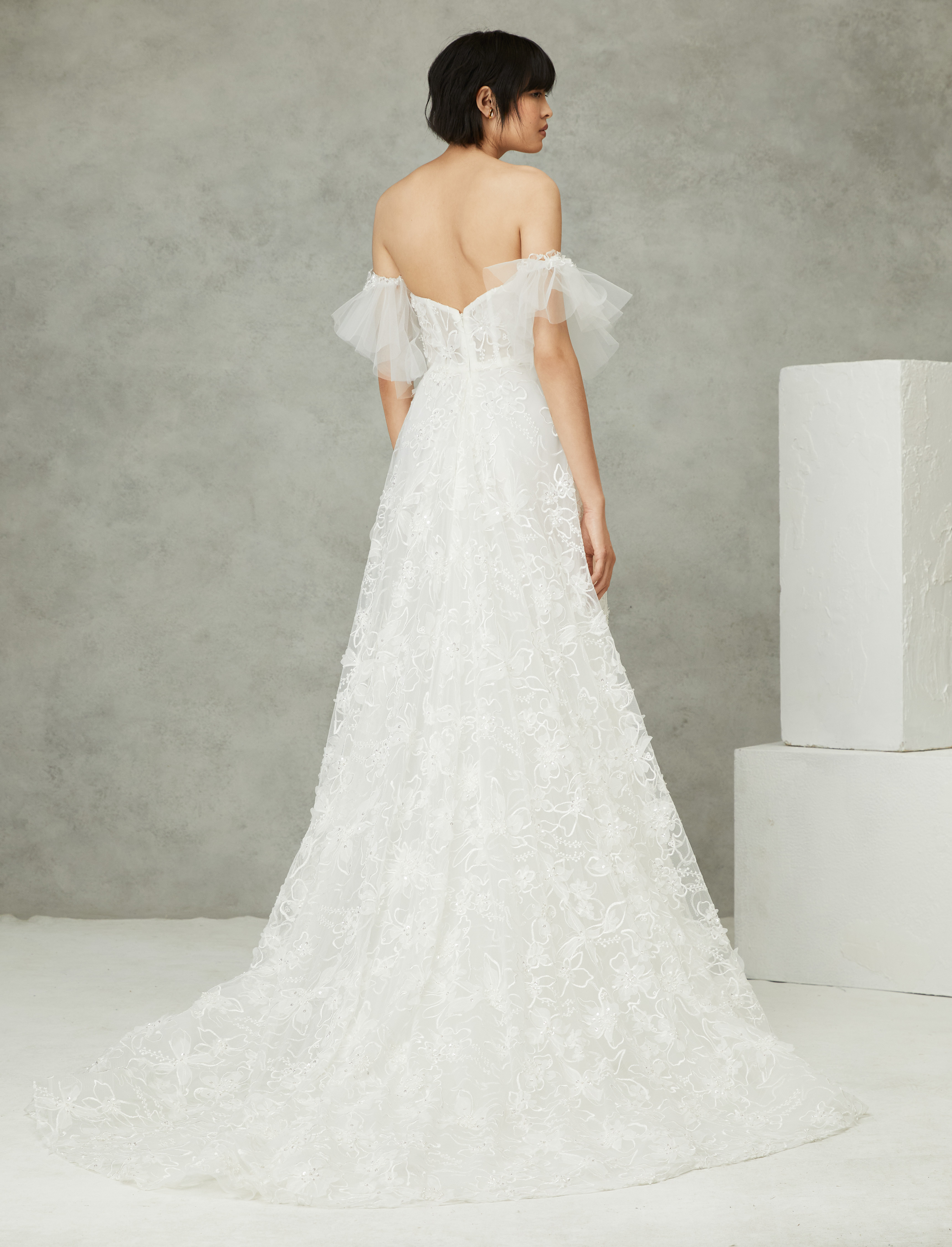 Back view of Belle ivory ball gown with corset bodice, detachable tulle flutter sleeves, and full skirt.