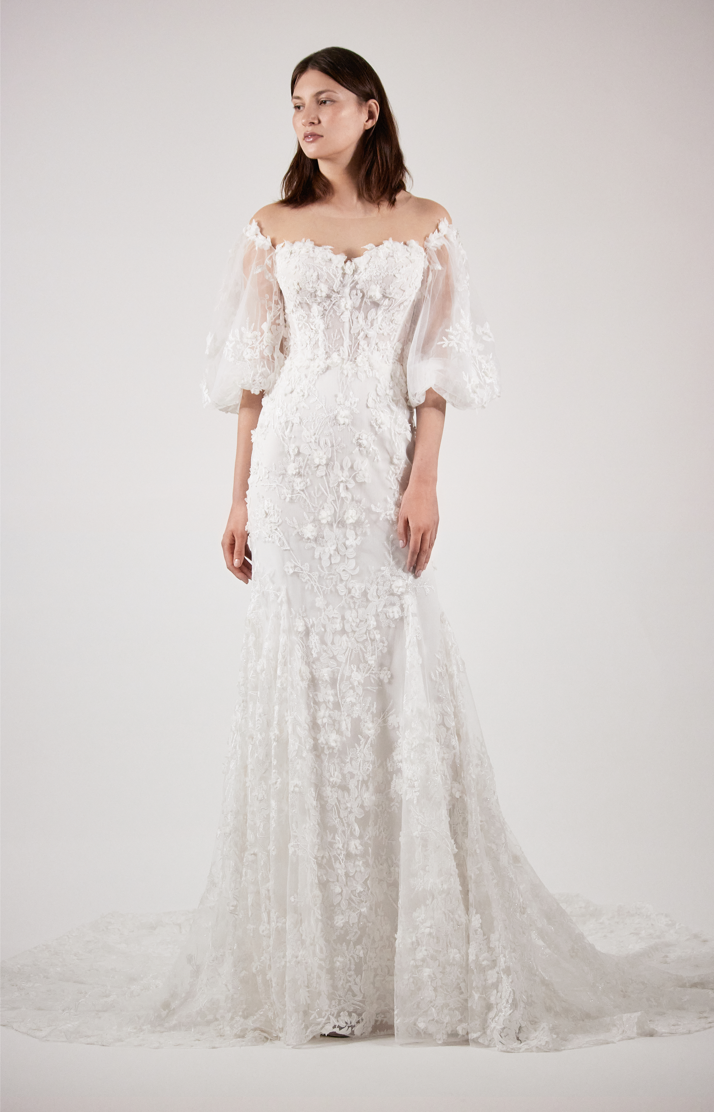 Bride wearing the Neva lace sheath gown with portrait neckline and balloon sleeves.