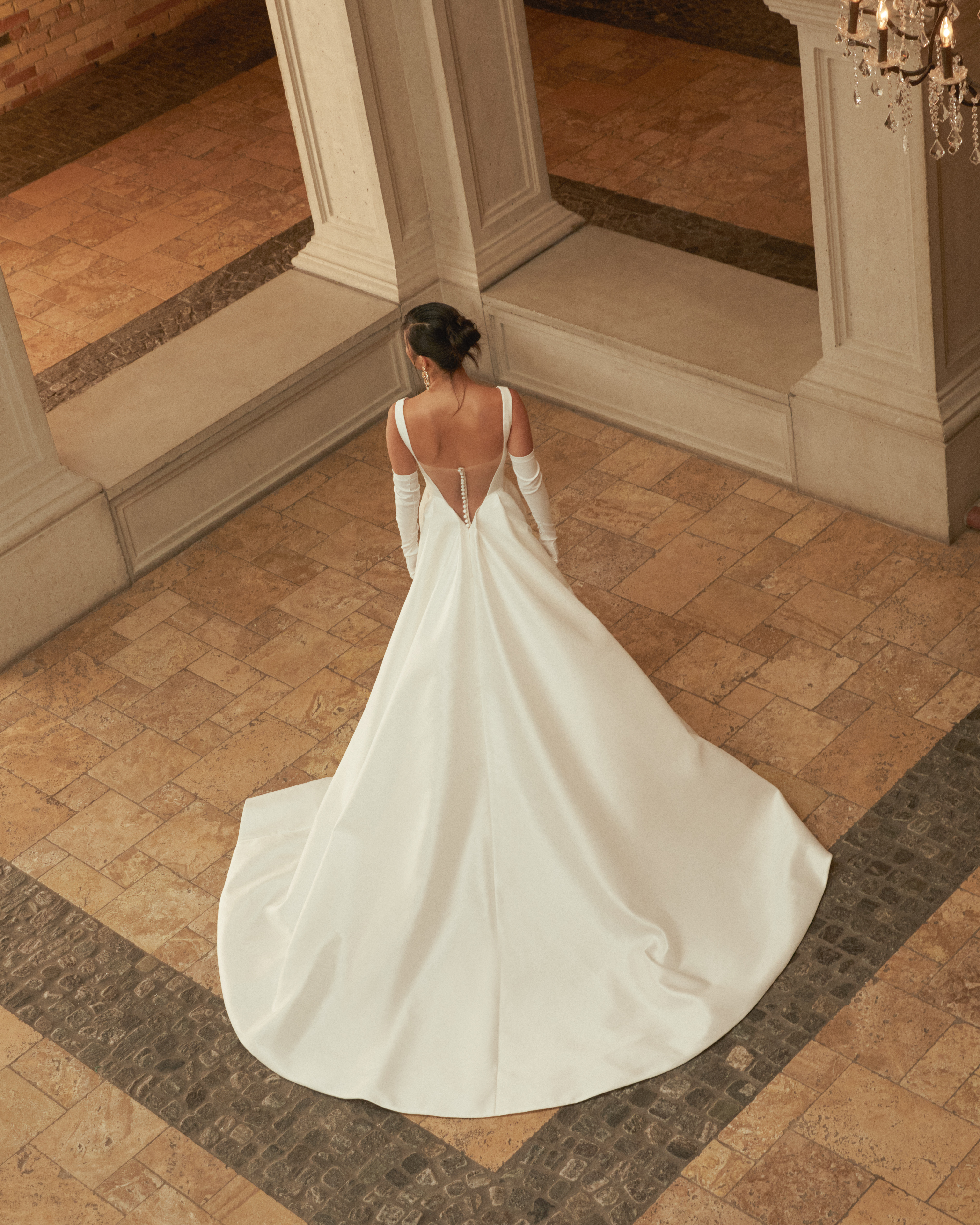 Back view of the Rowan gown, showing the full overskirt train and sculpted silhouette.