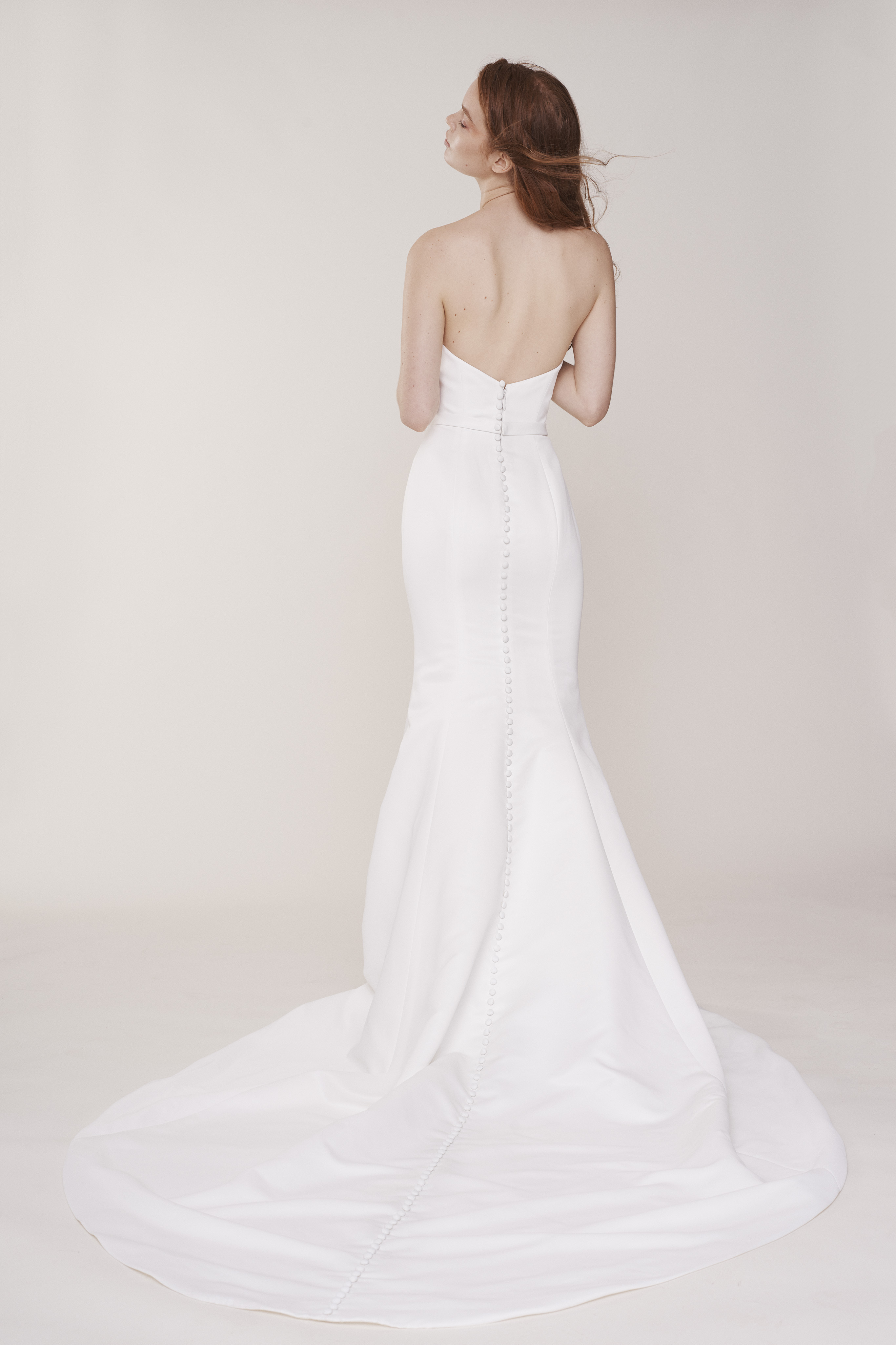 Back view of Windsor ivory matte satin flared gown with deep V bodice and flowing skirt.