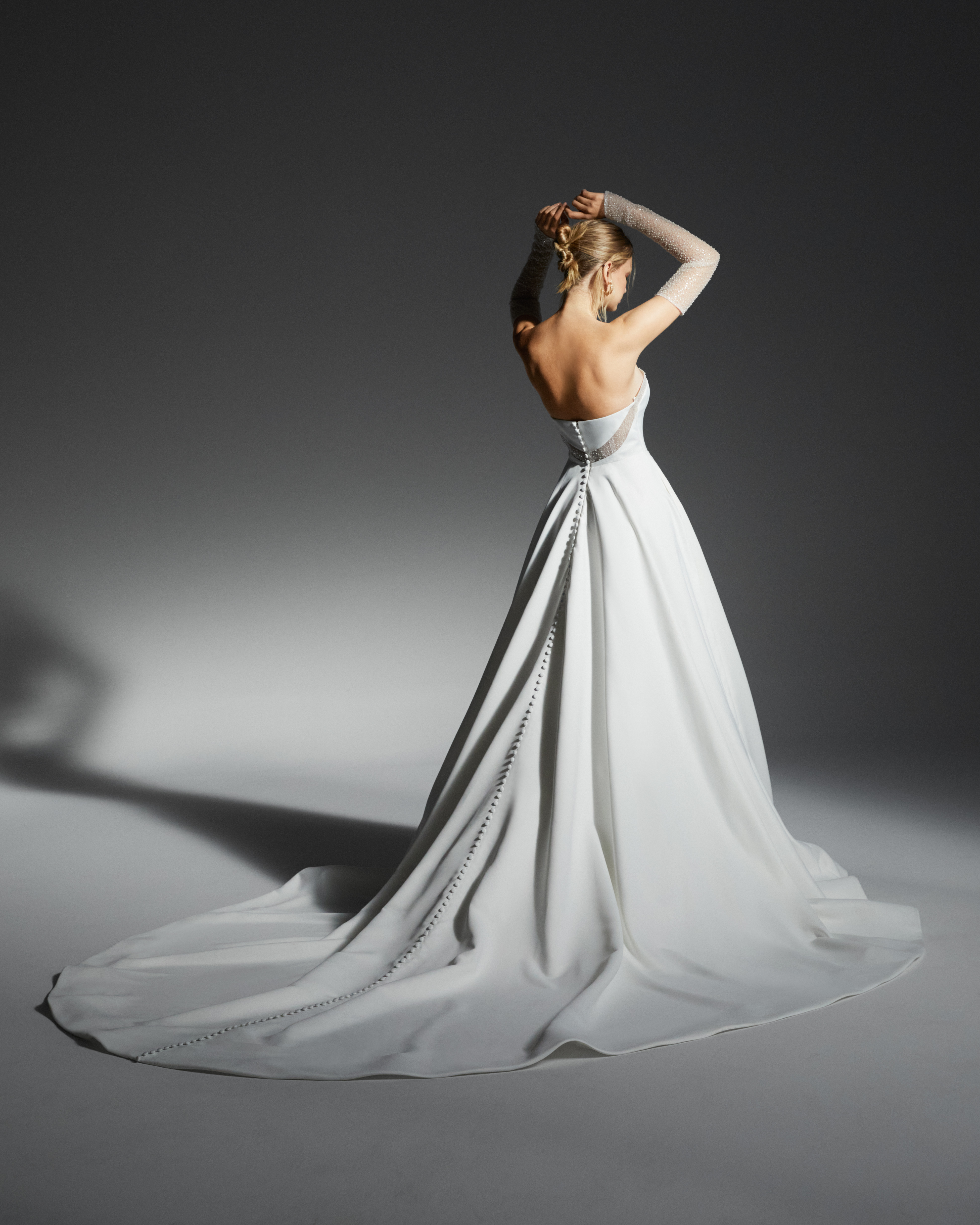 Back view of Cassidy strapless ball gown with detachable lace sleeves and full skirt.