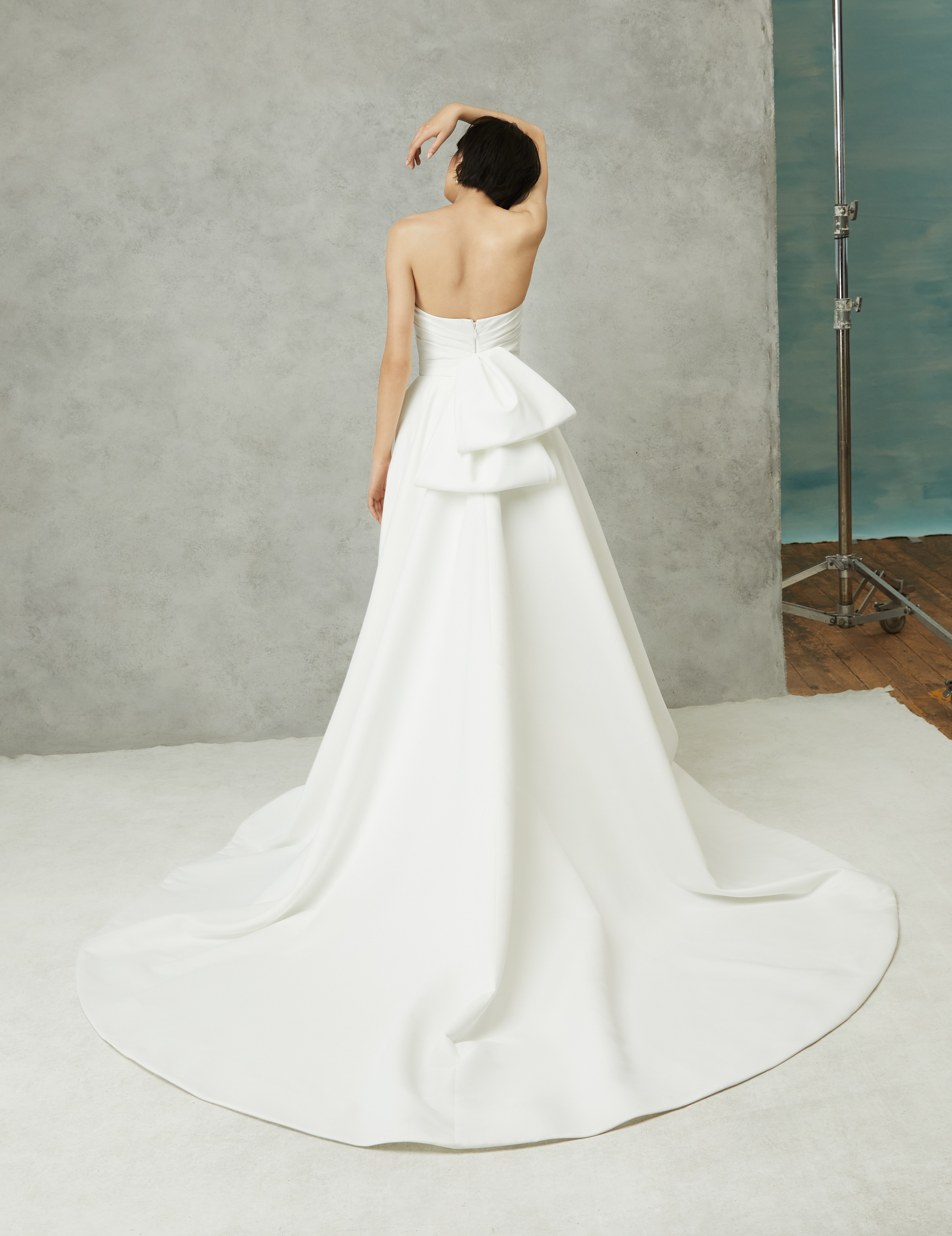 Back view of Lena ivory matte satin ball gown with draped bodice detail and full skirt.