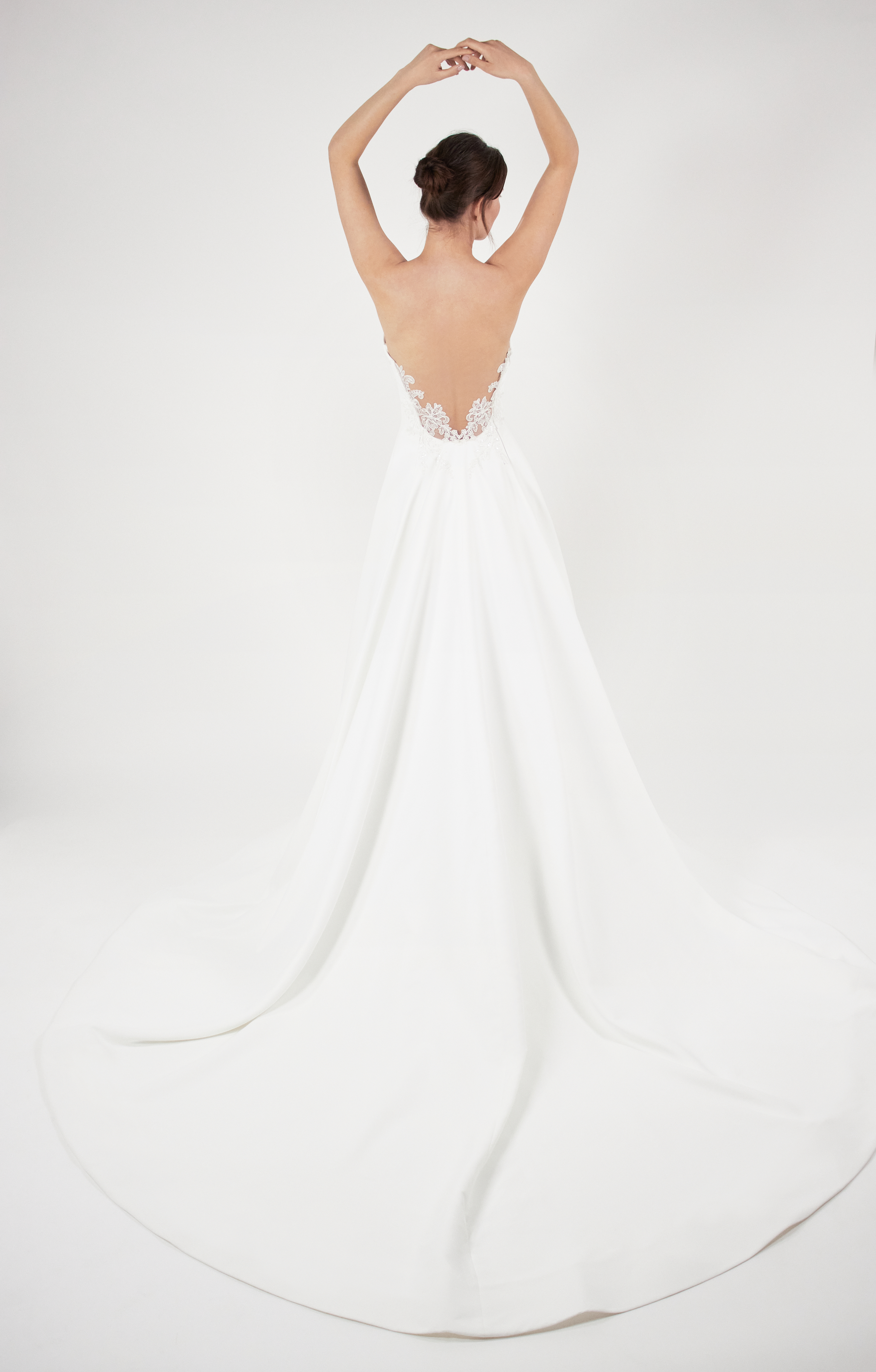 Back view of Makayla ivory ball gown with tattooed lace back detail and full skirt.