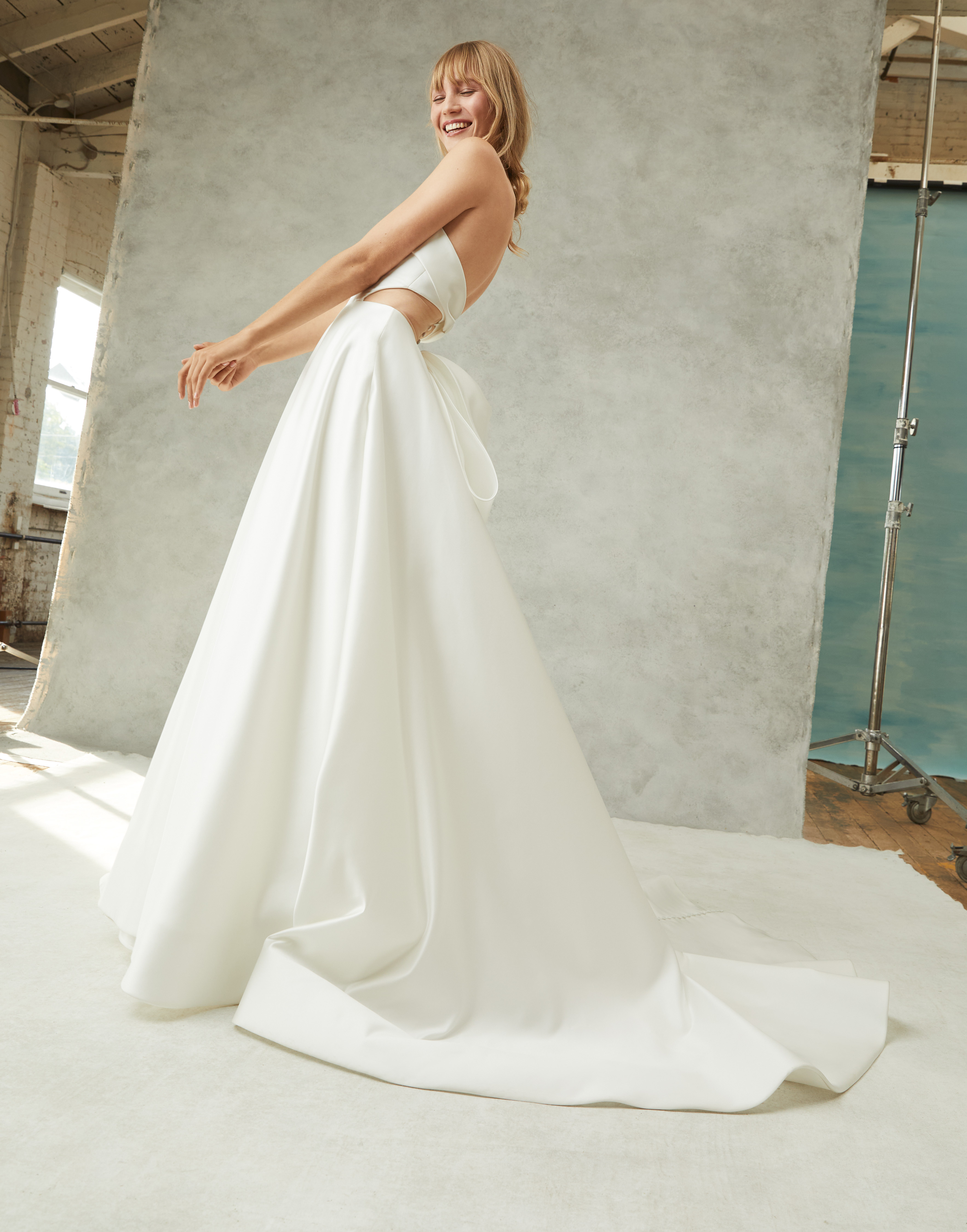 Side view of Regina strapless satin ball gown with draped neckline, full skirt, and grand bow.