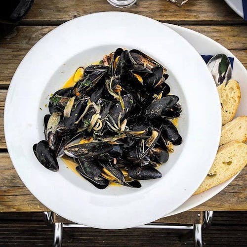 A bowl of mussels with fresh bread
