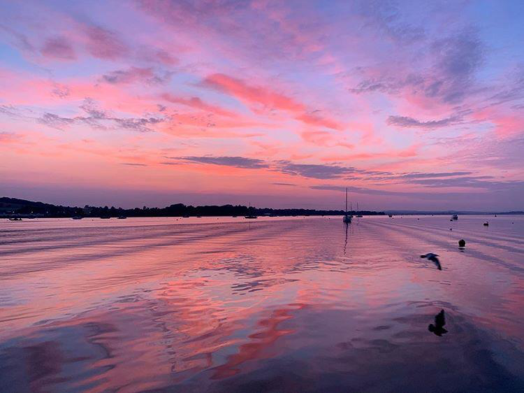 Pink and purple skies reflected in the River Exe at Sunset