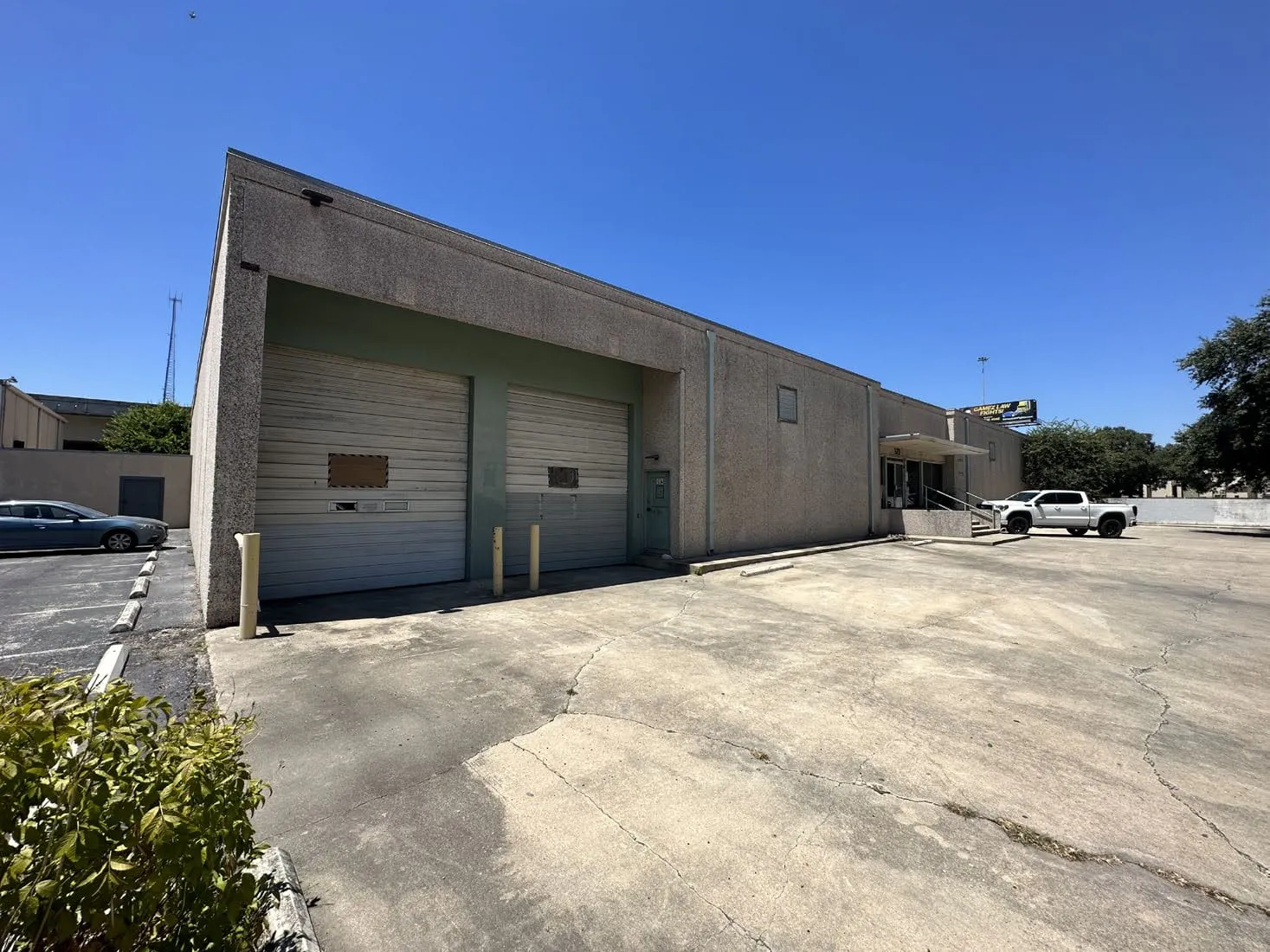 Concrete warehouse on Urban Loop Road with two roll-up bay doors, a canopied entrance and a parking apron