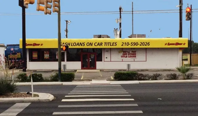 Single-tenant retail building on Walzem Road with a yellow title-loan sign band across its front, seen from across the street