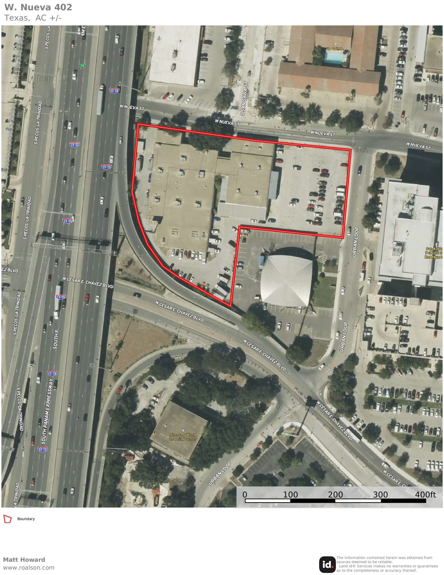 Aerial view of a downtown San Antonio block outlined in red, holding a low office building and its parking, beside Cesar E. Chavez Boulevard