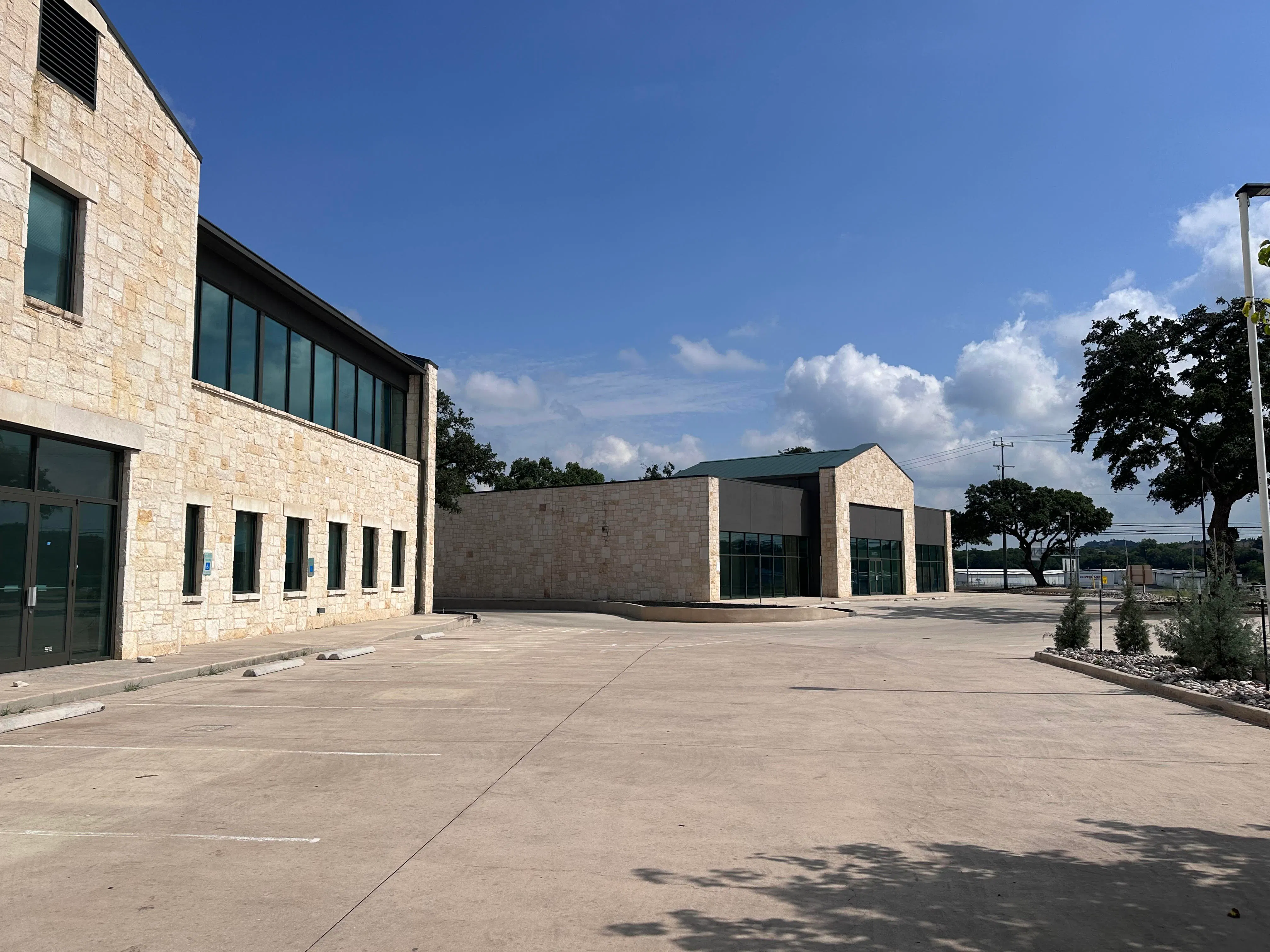 Two limestone and glass commercial buildings around a parking court at 25331 IH 10 West