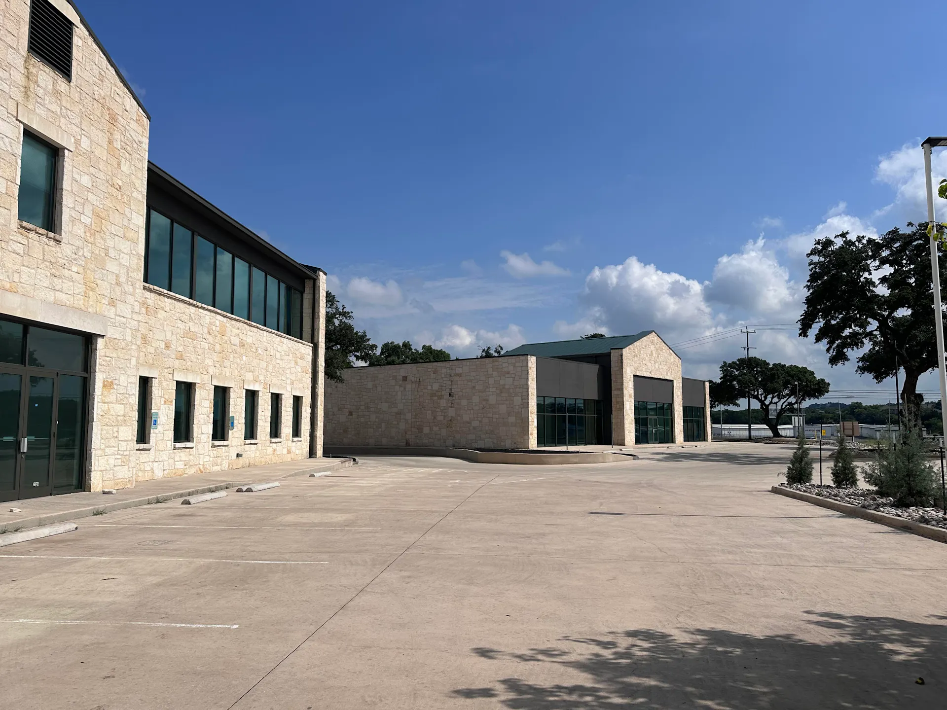 Two limestone and glass commercial buildings around a parking court at 25331 IH 10 West