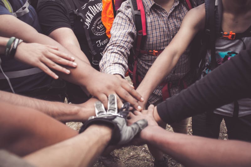 Many people holding their hands together