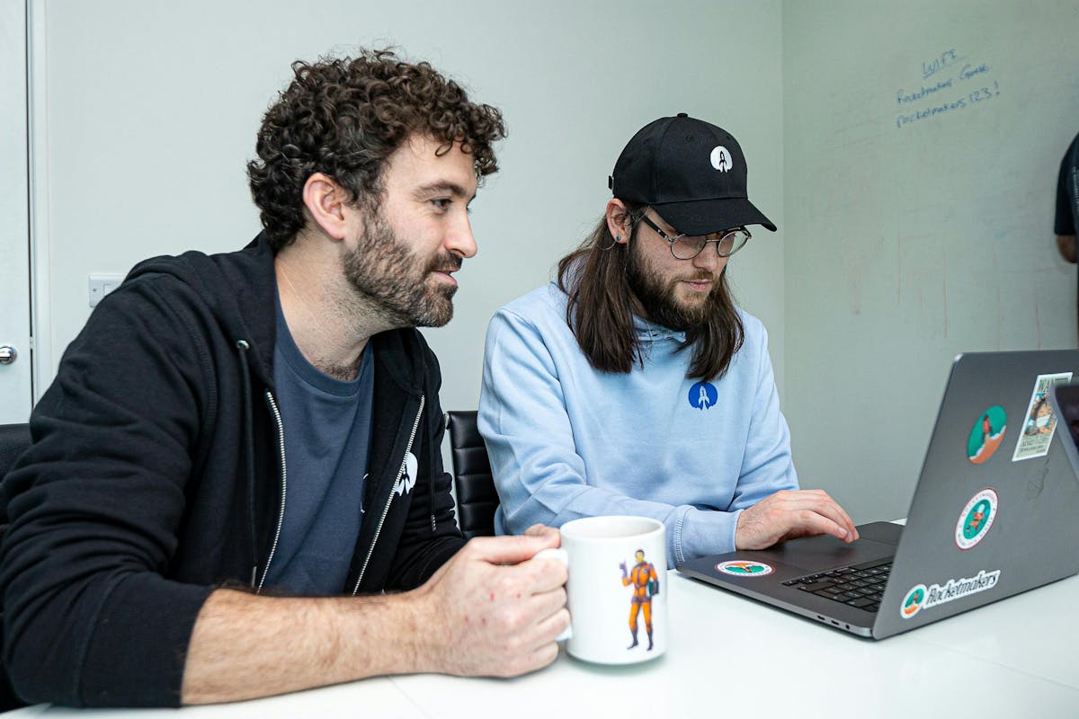 photo of two people working at a laptop