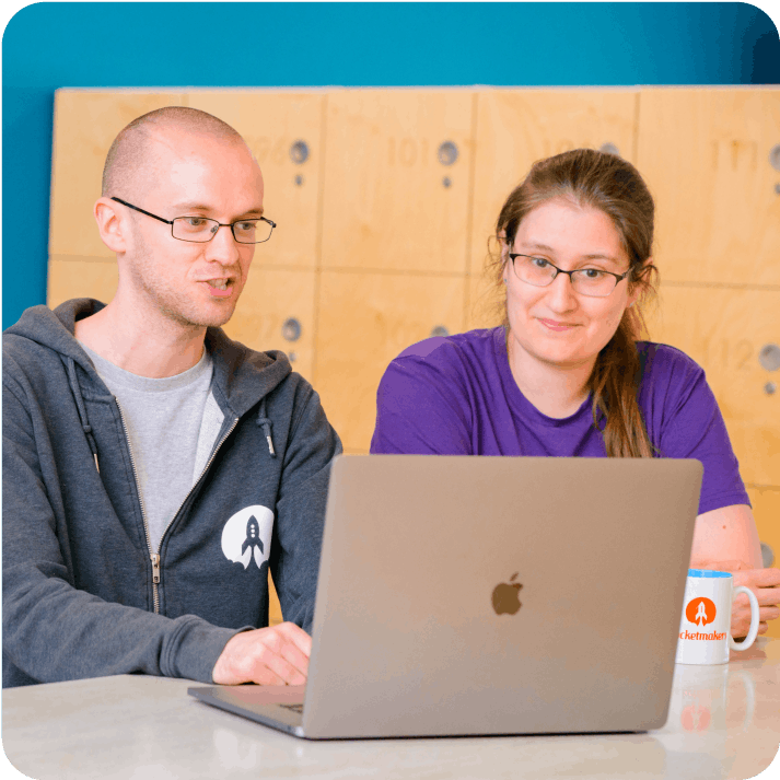 Two developers working on a laptop