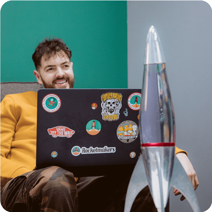 Designer smiling while working on a laptop