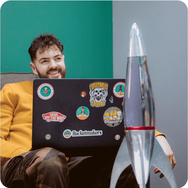 Person smiling while working on a laptop