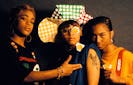 TLC poses for a photograph. Lisa Left Eye Lopes wears a condom in her glasses.