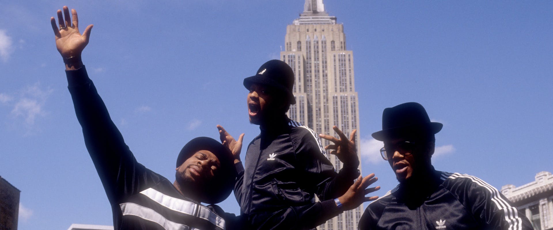 Joseph Simmons, Darryl McDaniels and Jam Master Jay of the hip-hop group "Run DMC" pose for a portrait session wearing Addidas sweat suits in front of the Empire State Building in May 1985 in New York, New York. 
