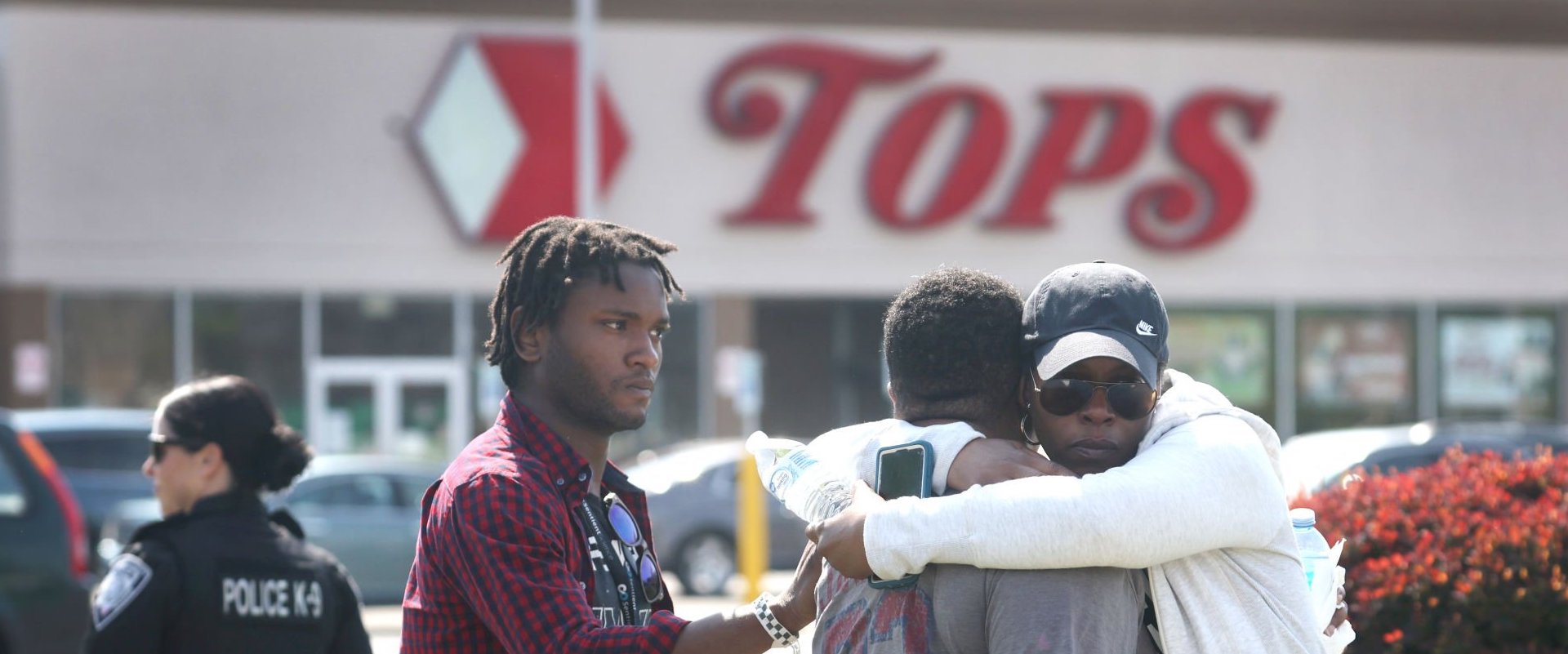 People gather outside of Tops market on May 15, 2022 in Buffalo, New York. Yesterday a gunman opened fire at the store, killing ten people and wounding another three. Suspect Payton Gendron was taken into custody and charged with first degree murder. U.S. Attorney Merrick Garland released a statement, saying the US Department of Justice is investigating the shooting "as a hate crime and an act of racially-motivated violent extremism". (Photo by Scott Olson/Getty Images)