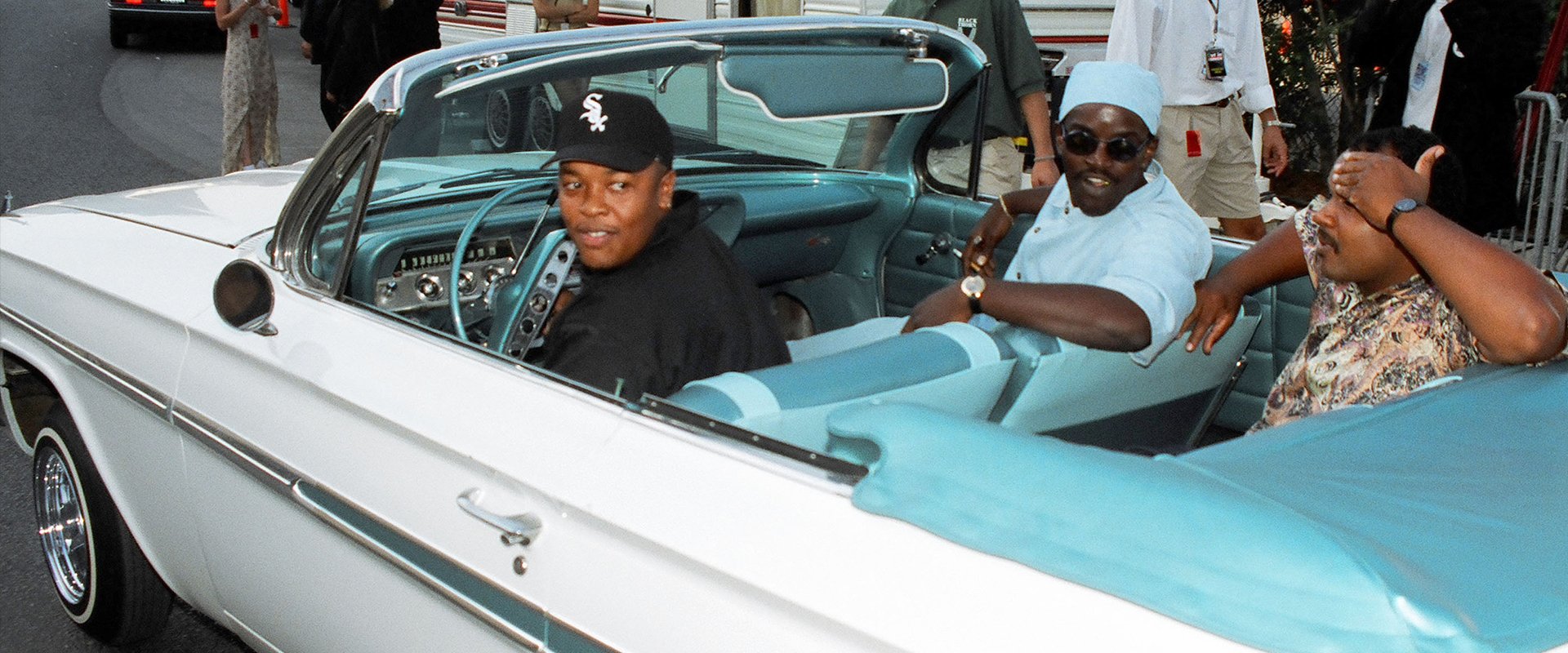 Dr. Dre and others in a convertible. 