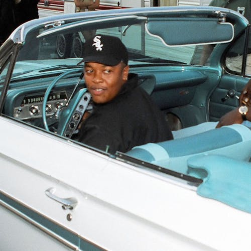 Dr. Dre and others in a convertible. 