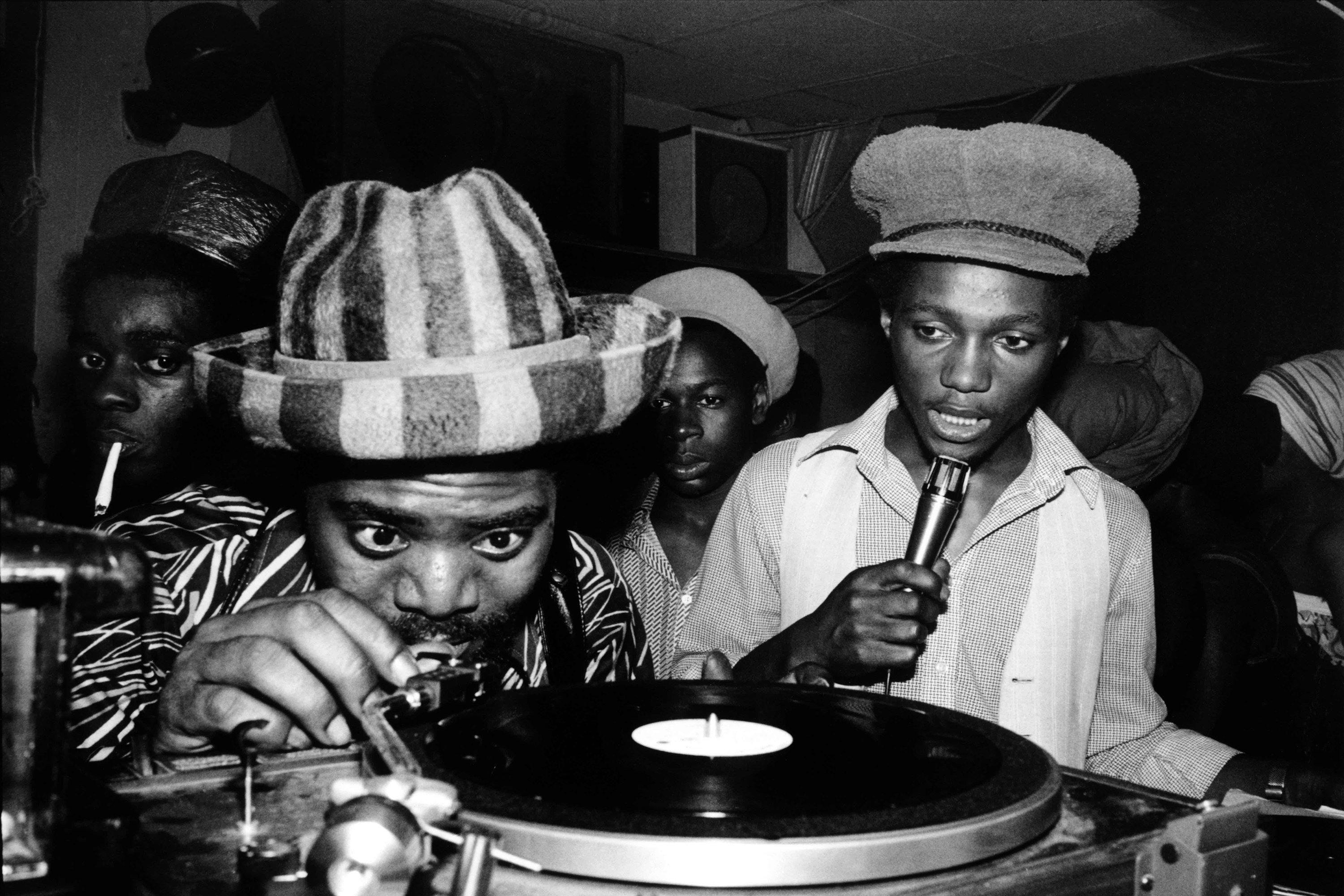 Coxsone Dodd places the needle on a record.