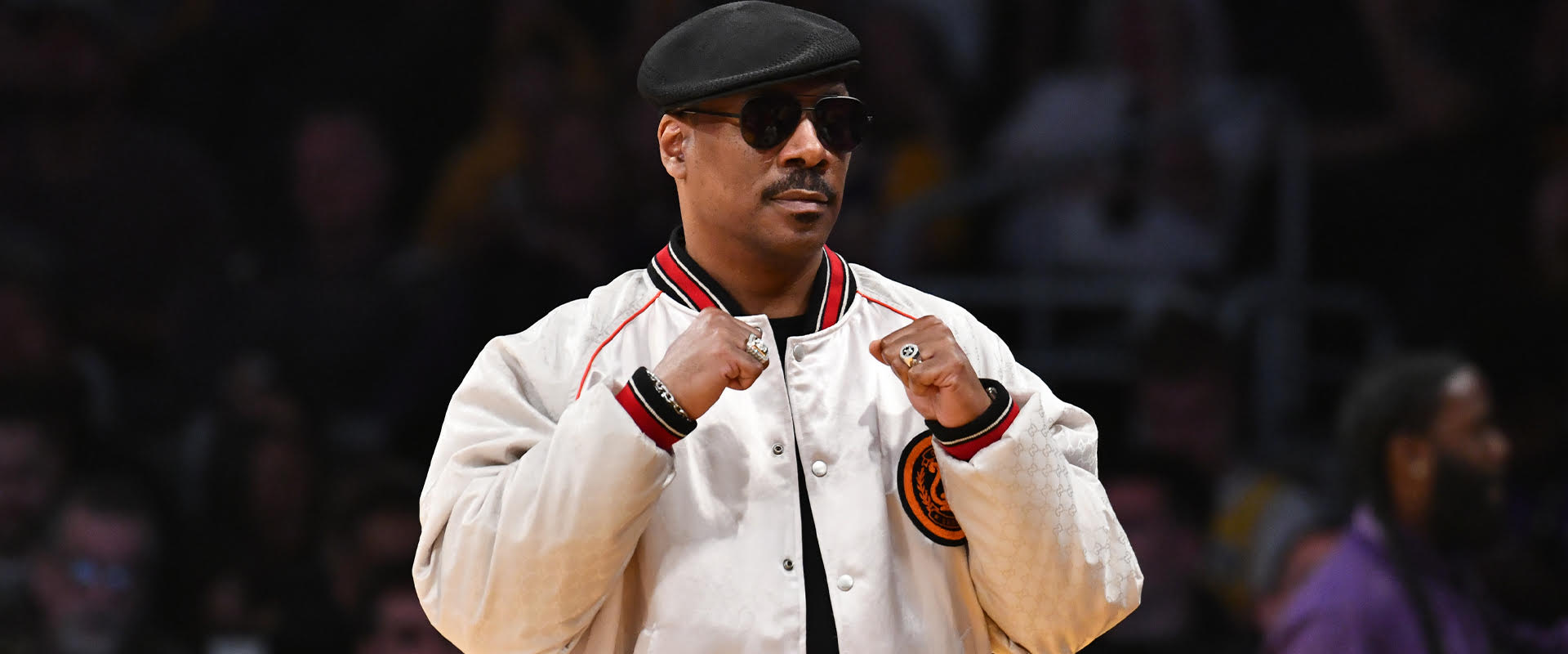 Eddie Murphy poses with his two fists up.