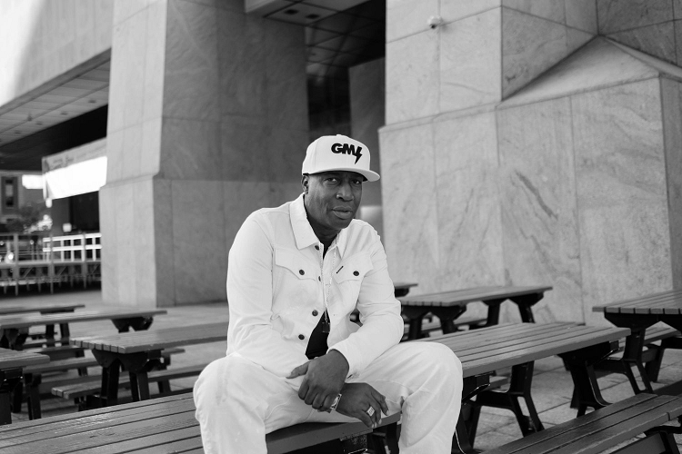Grandmaster Flash sits on a bench