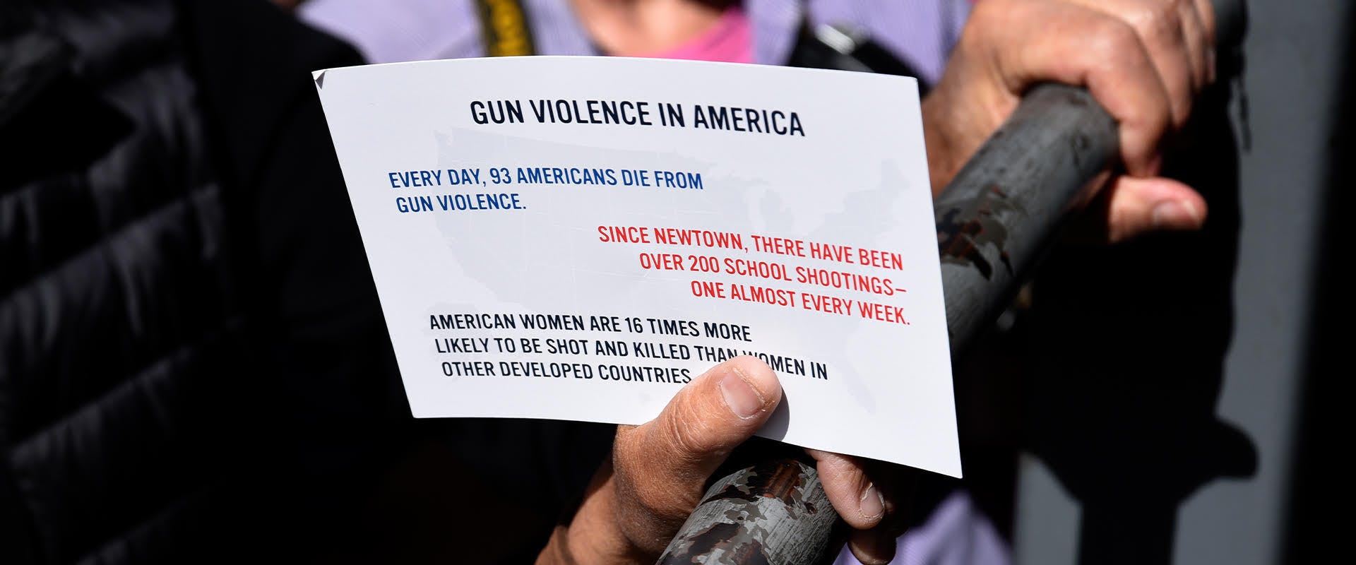 A photograph with a sign showing the prevalence of gun violence in the United States