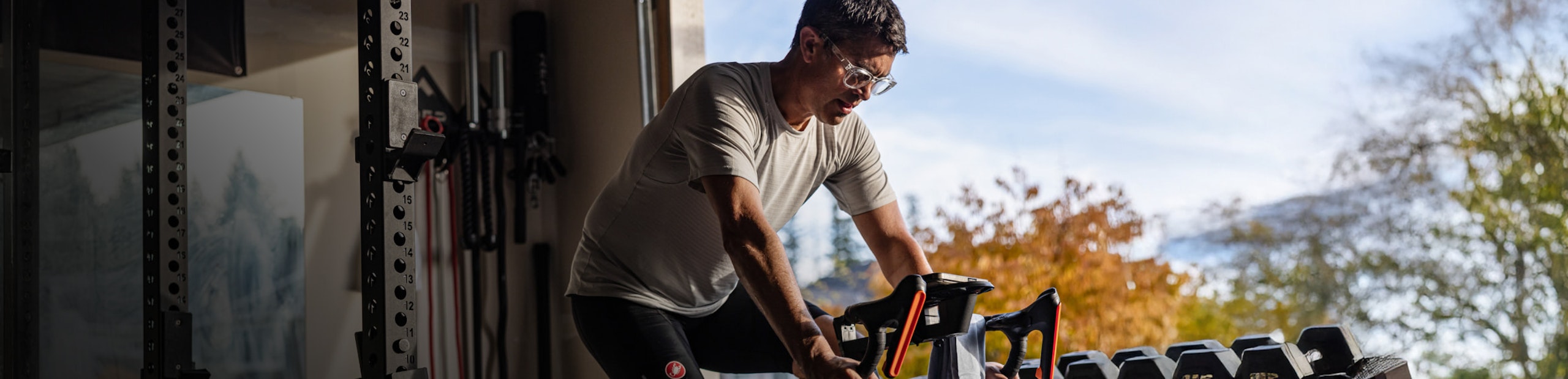 Man riding trainer with reading glasses